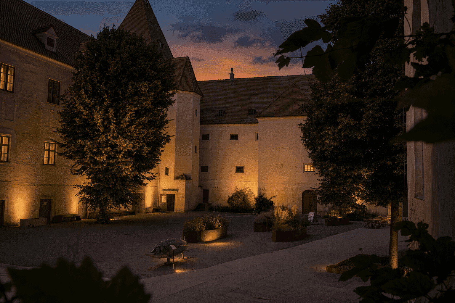 Warm beleuchteter Innenhof von Schloss Orth in der Dämmerung