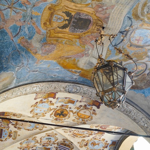 התקרה מעוטרת בפרסקאות צבעוניות ופנס גדול ומפואר.