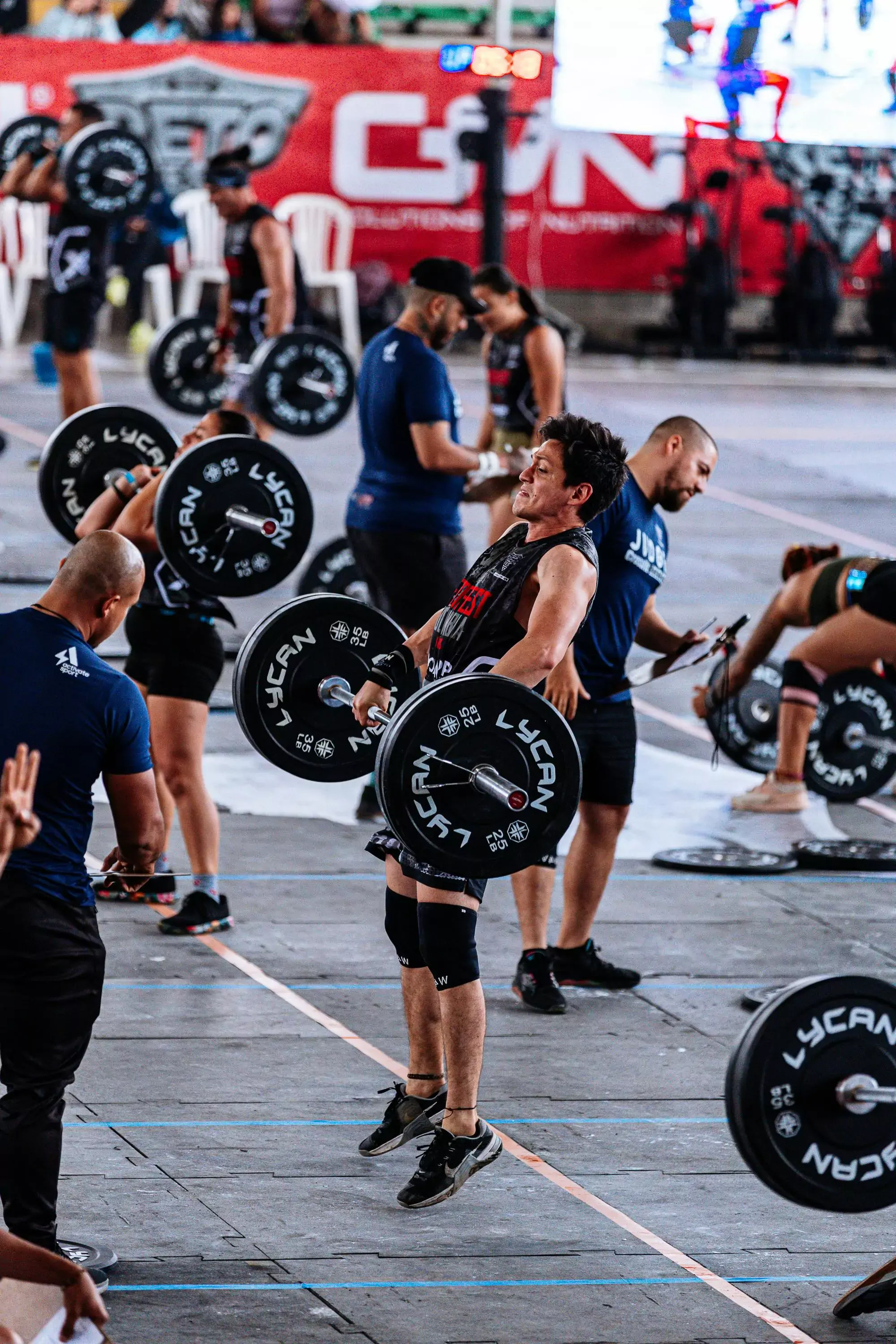 a crossfit athlete in a competition in the middle of completing a clean