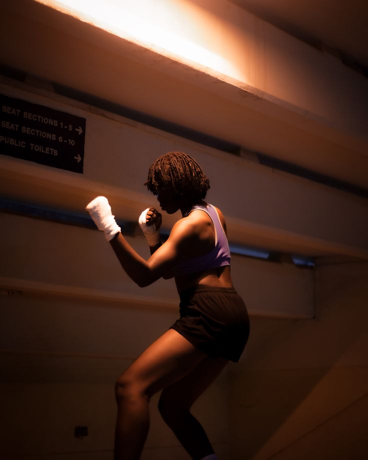 Woman in boxing stance with hand wraps.