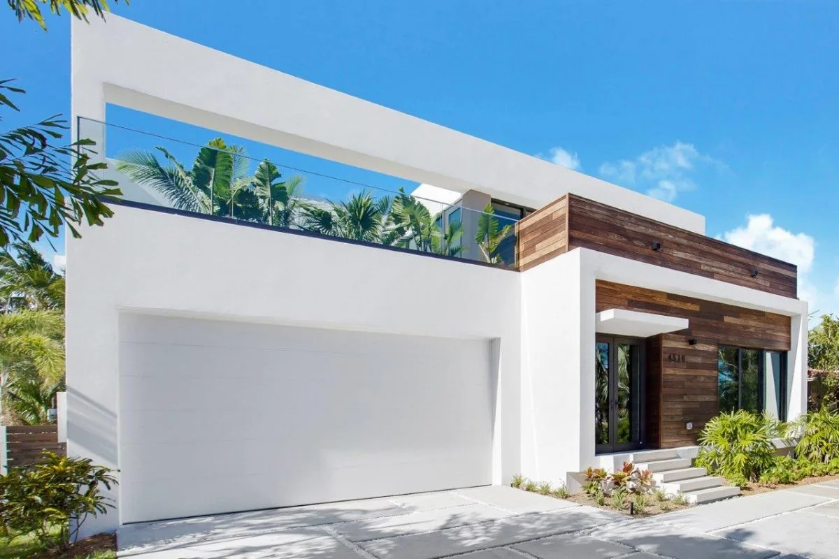Street view of modern white two-story home with rooftop terrace and wood cladding in Miami Beach
