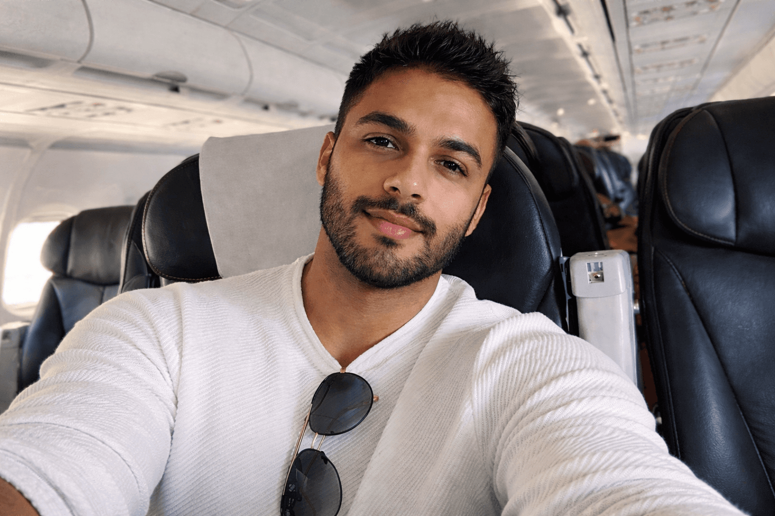 Portrait of a young man with a beard, smiling warmly at the camera.