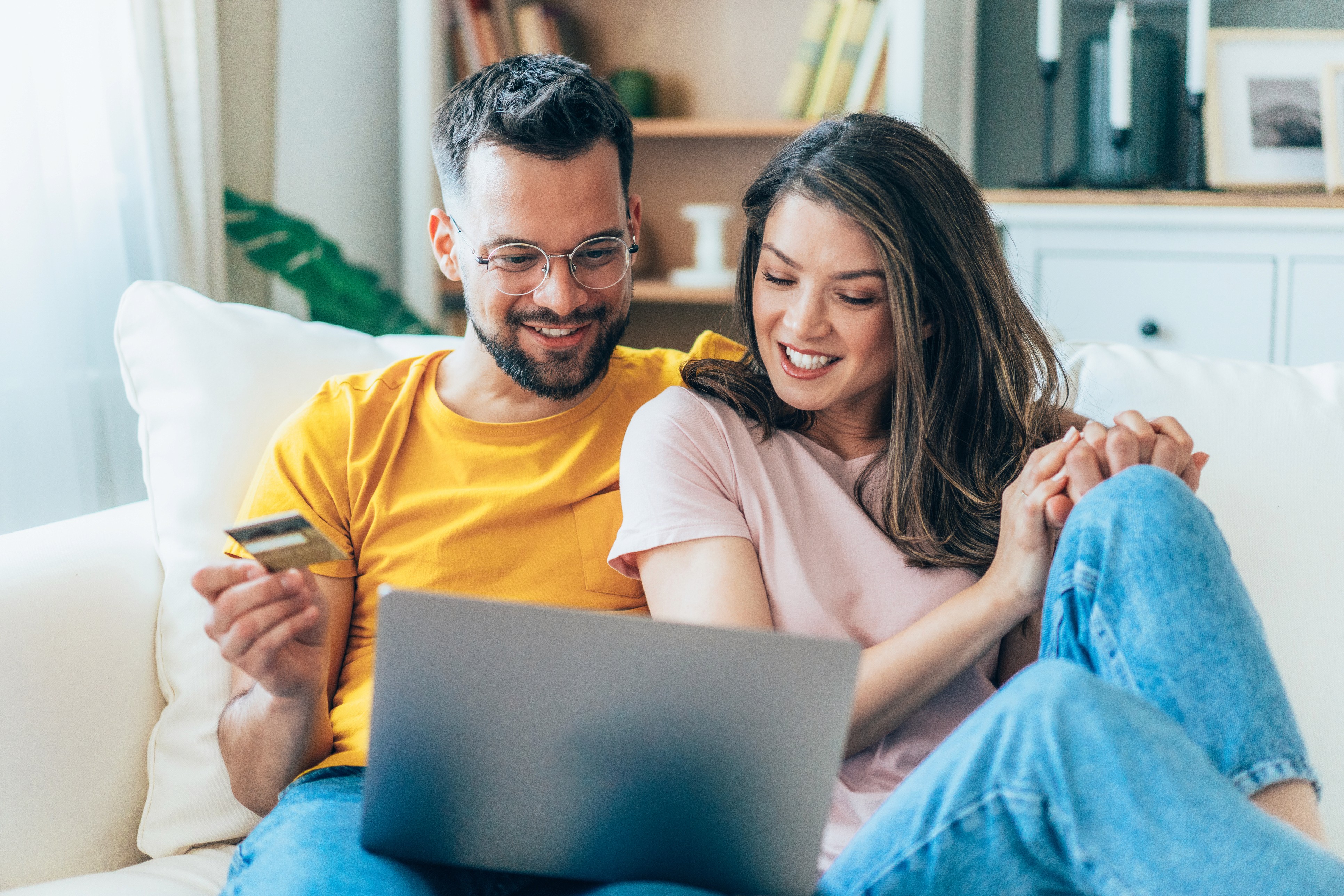 Happy couple shopping online with laptop and credit card