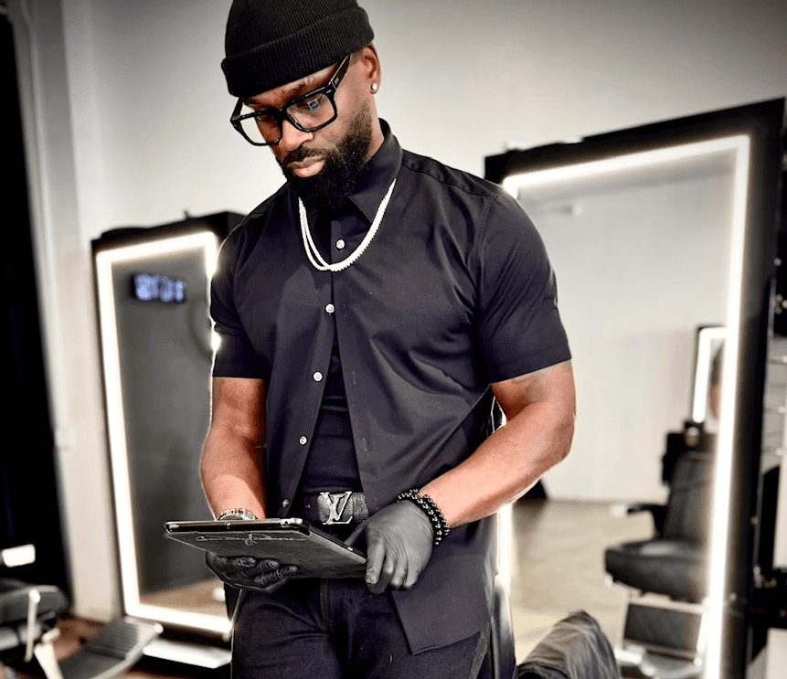 Courtney Palmore, also known as Barber.CLP, sitting confidently in a barber chair at The Rich Barber in West Hollywood, showcasing his expertise in professional grooming and luxury barbering services.