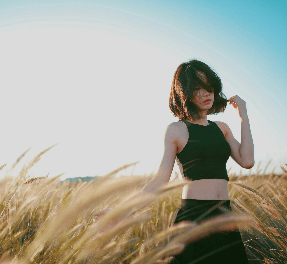 her way agency hero banner of an asian woman in a beautiful field setting during sunset