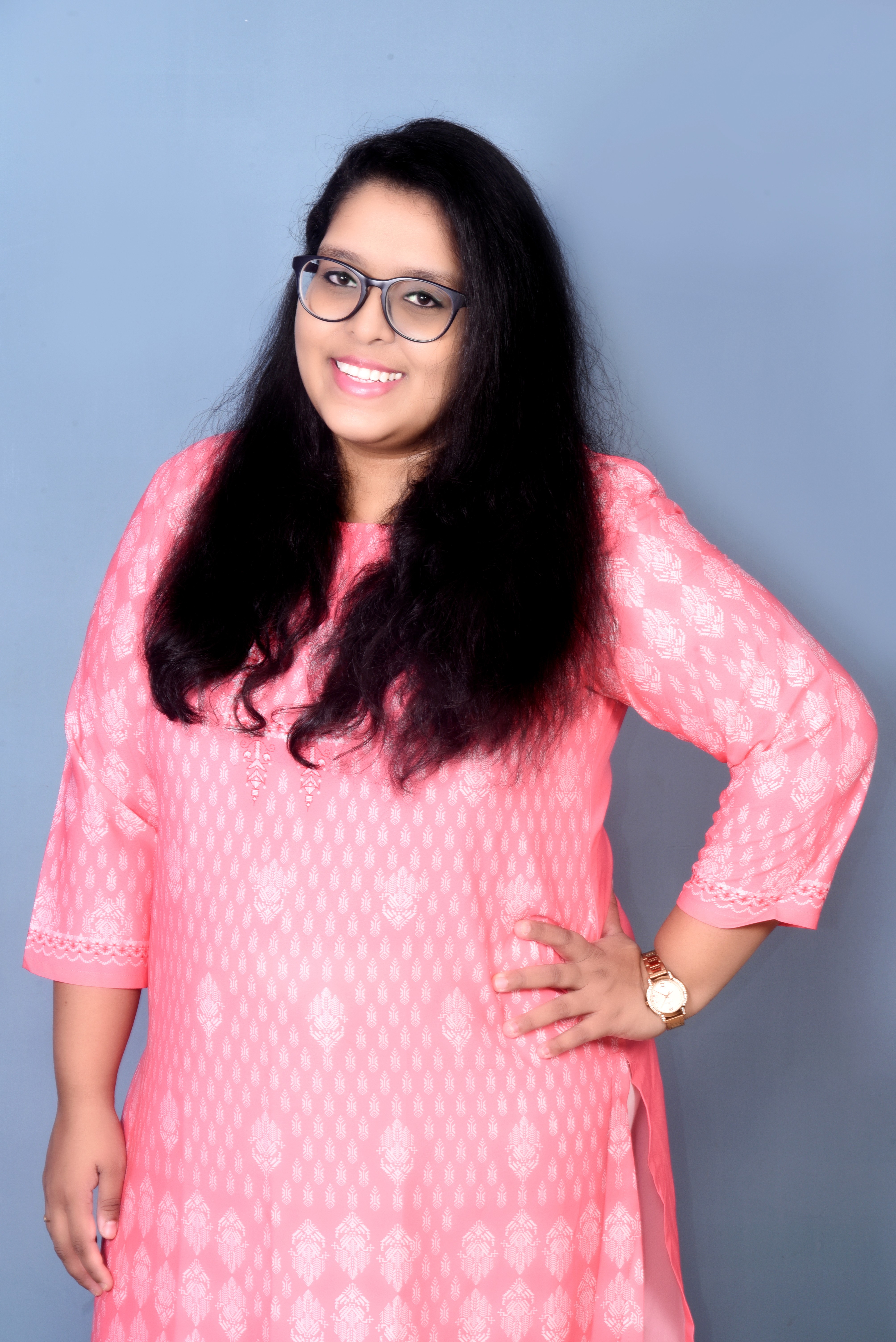 A businesswoman sitting at her desk, smiling and looking at the camera.