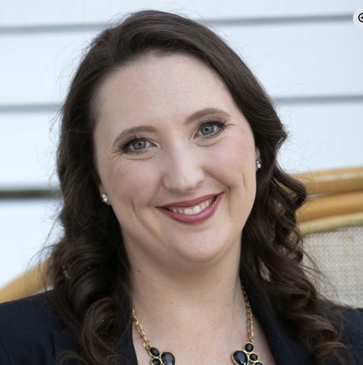 a woman sitting on a white chair next to a table