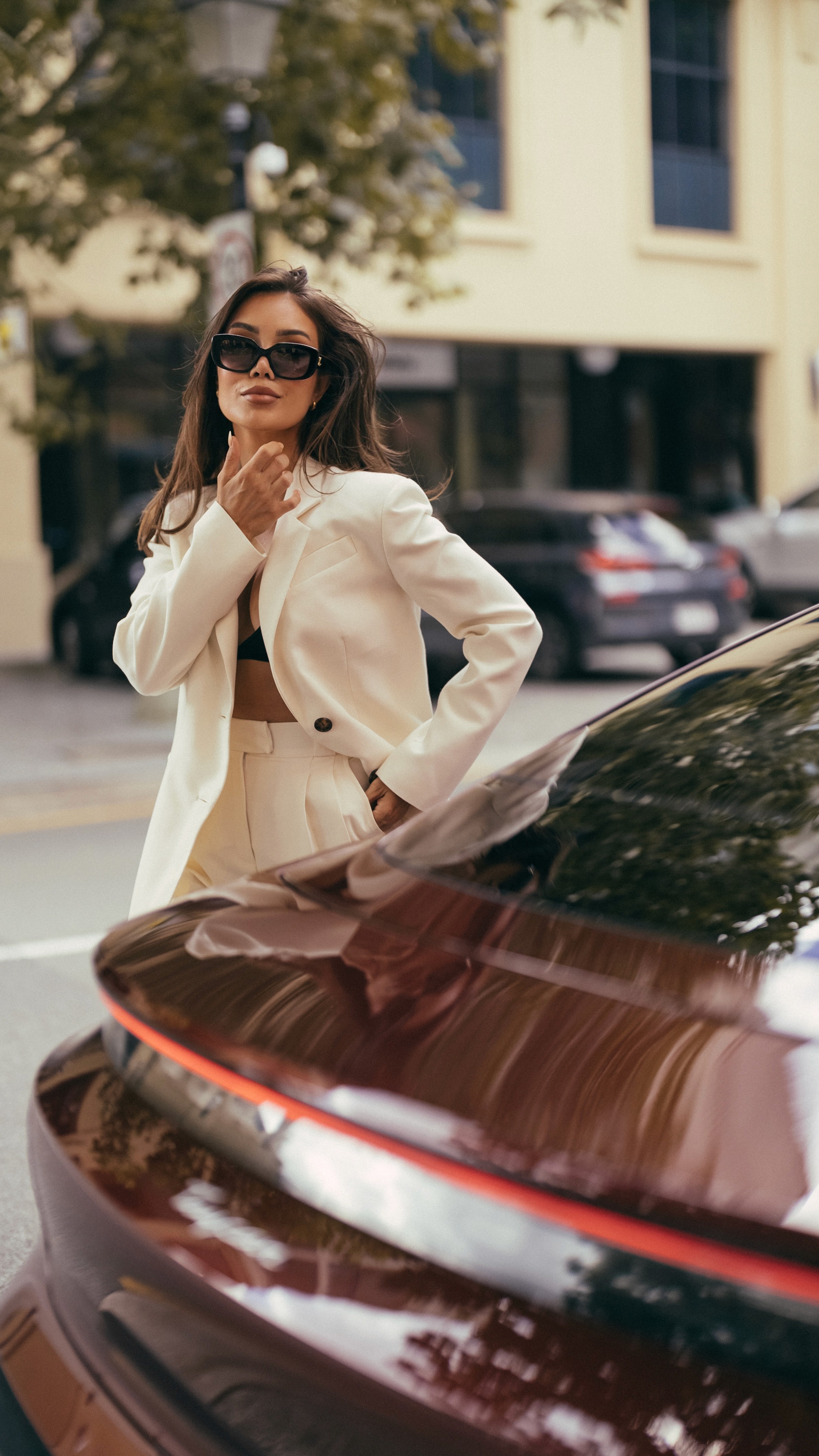 Pia Muehlenbeck walking around a Porsche Taycan to the office