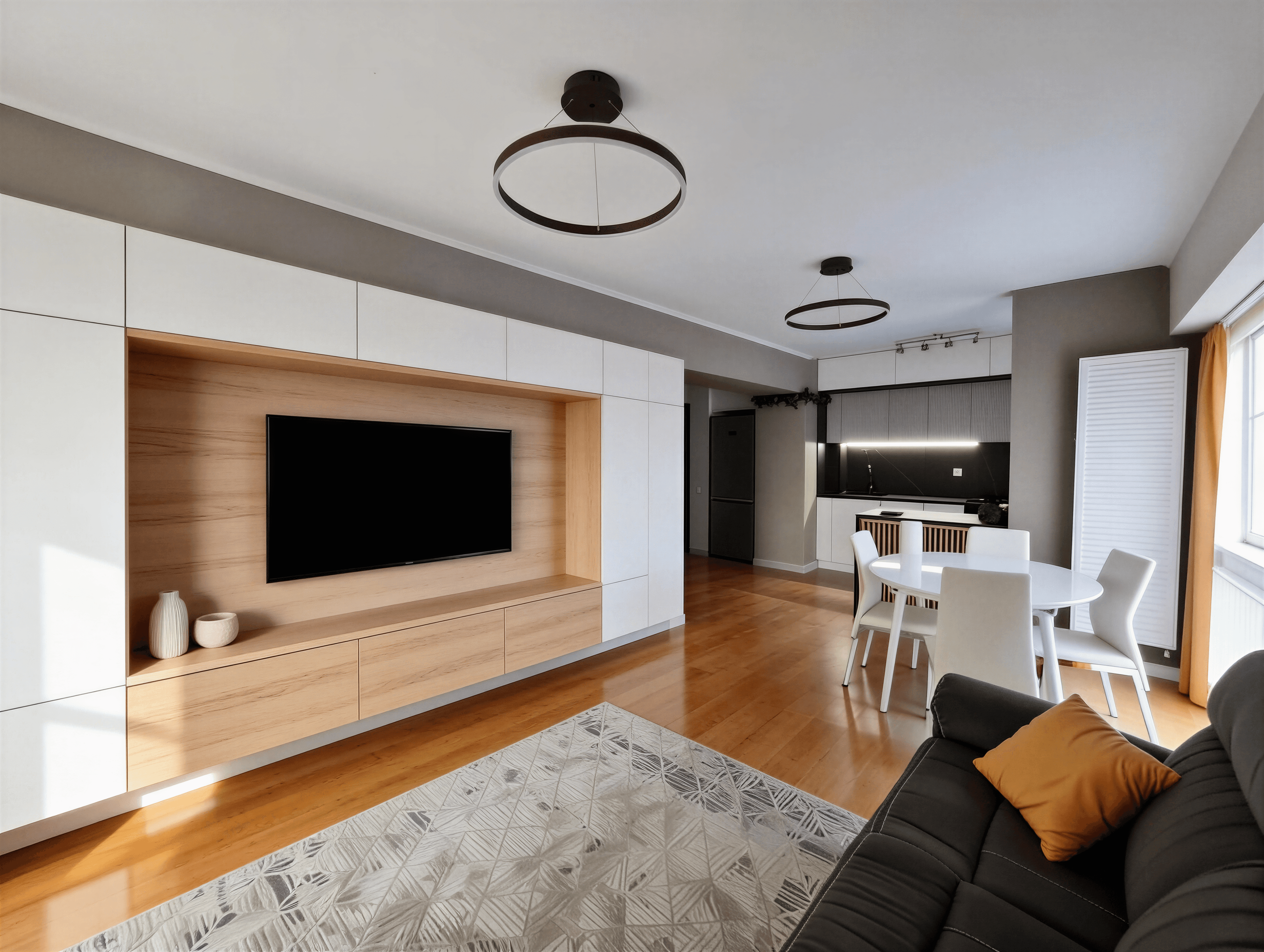 Perete media alb cu cadru din lemn, TV încastrat, zonă de living deschisă spre dining, lumină naturală.