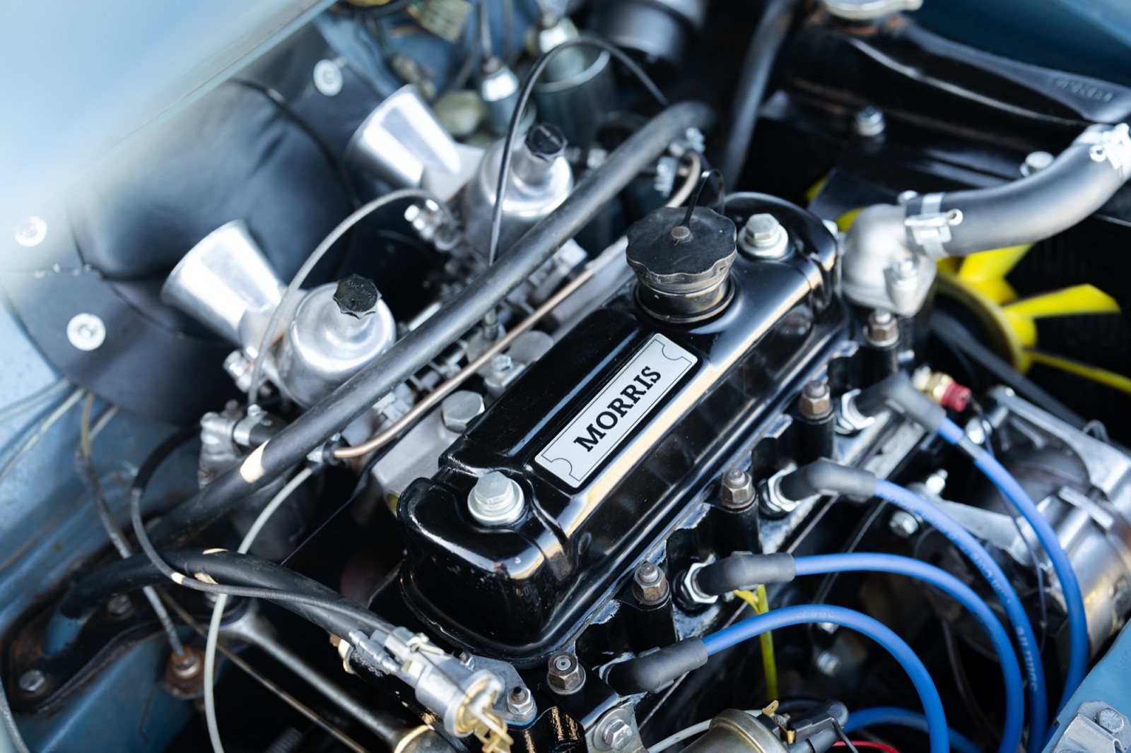 Close-up of a car engine showcasing polished metal parts, wires, and intricate machinery details.