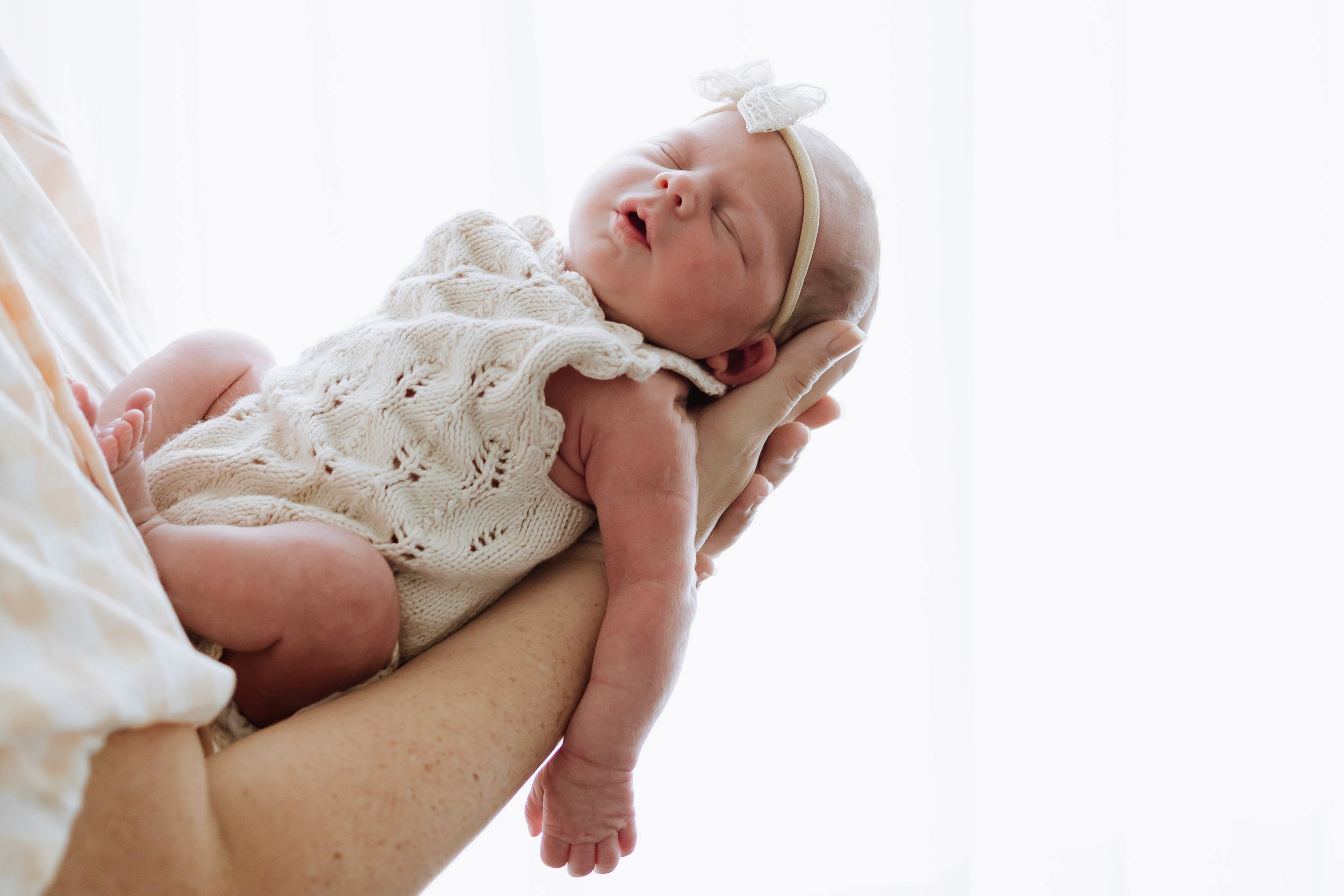 Portrait of newborn baby held in parent's arms in stuio newborn session Mackay