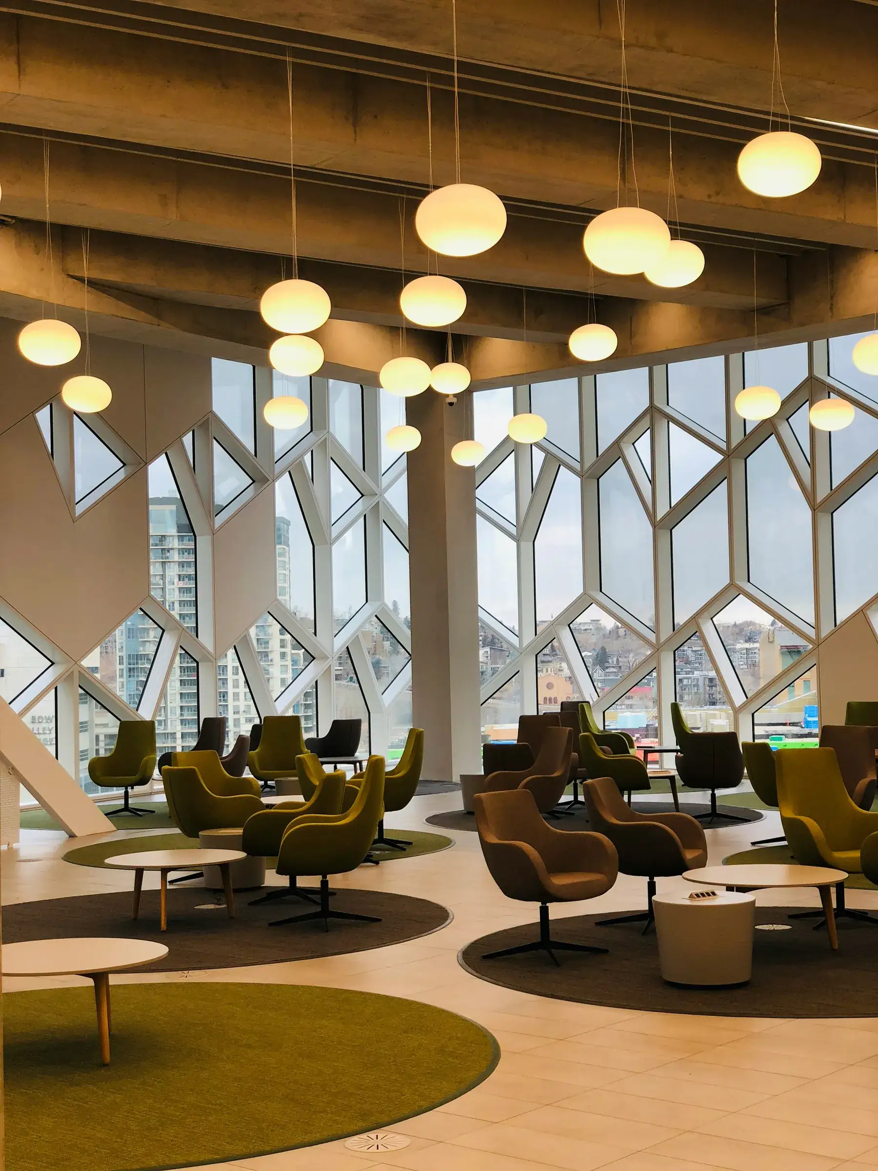 Library lounge with olive swivel chairs under globe pendant lights