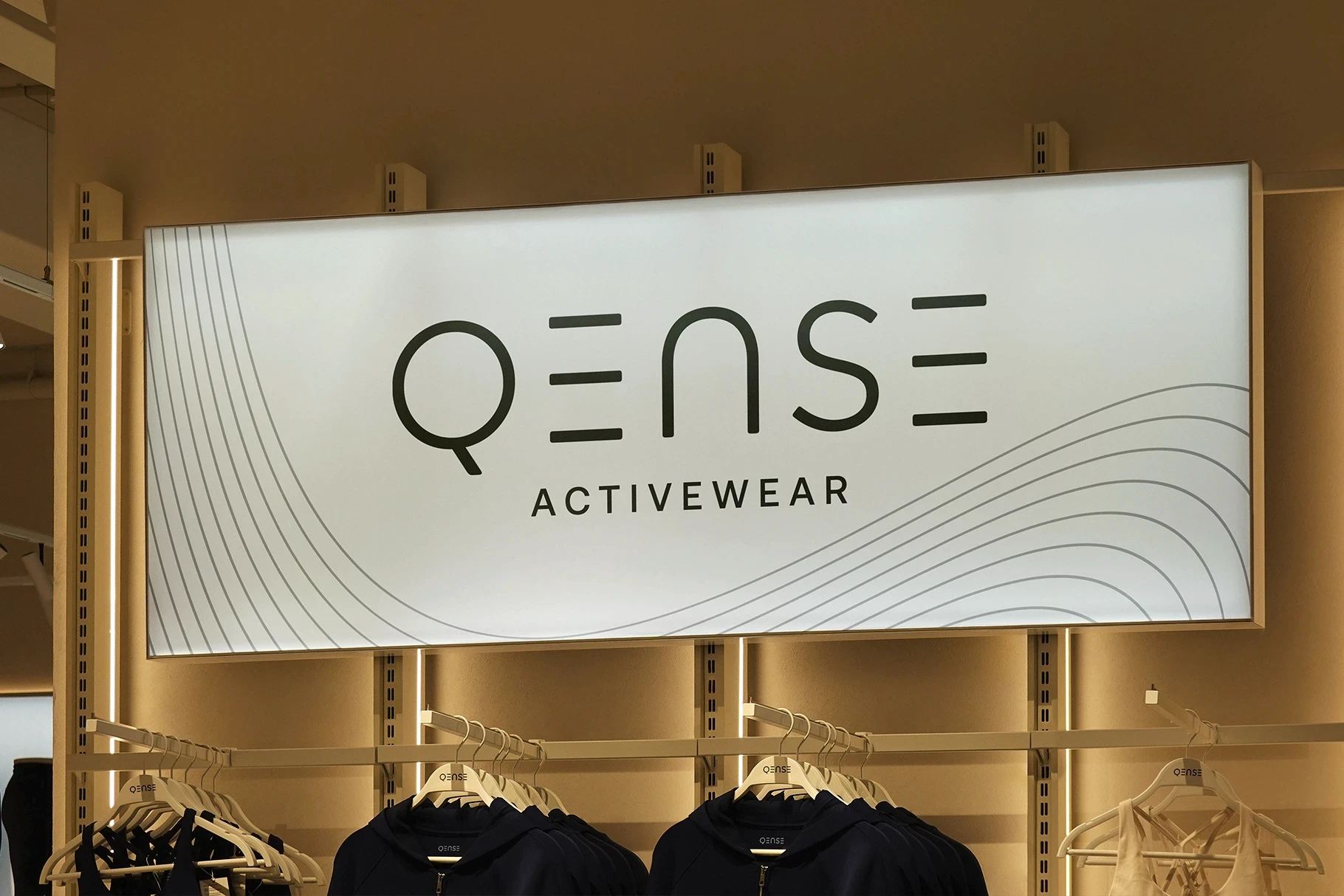 Illuminated lightbox mockup with an elegant activewear logo in a retail store.