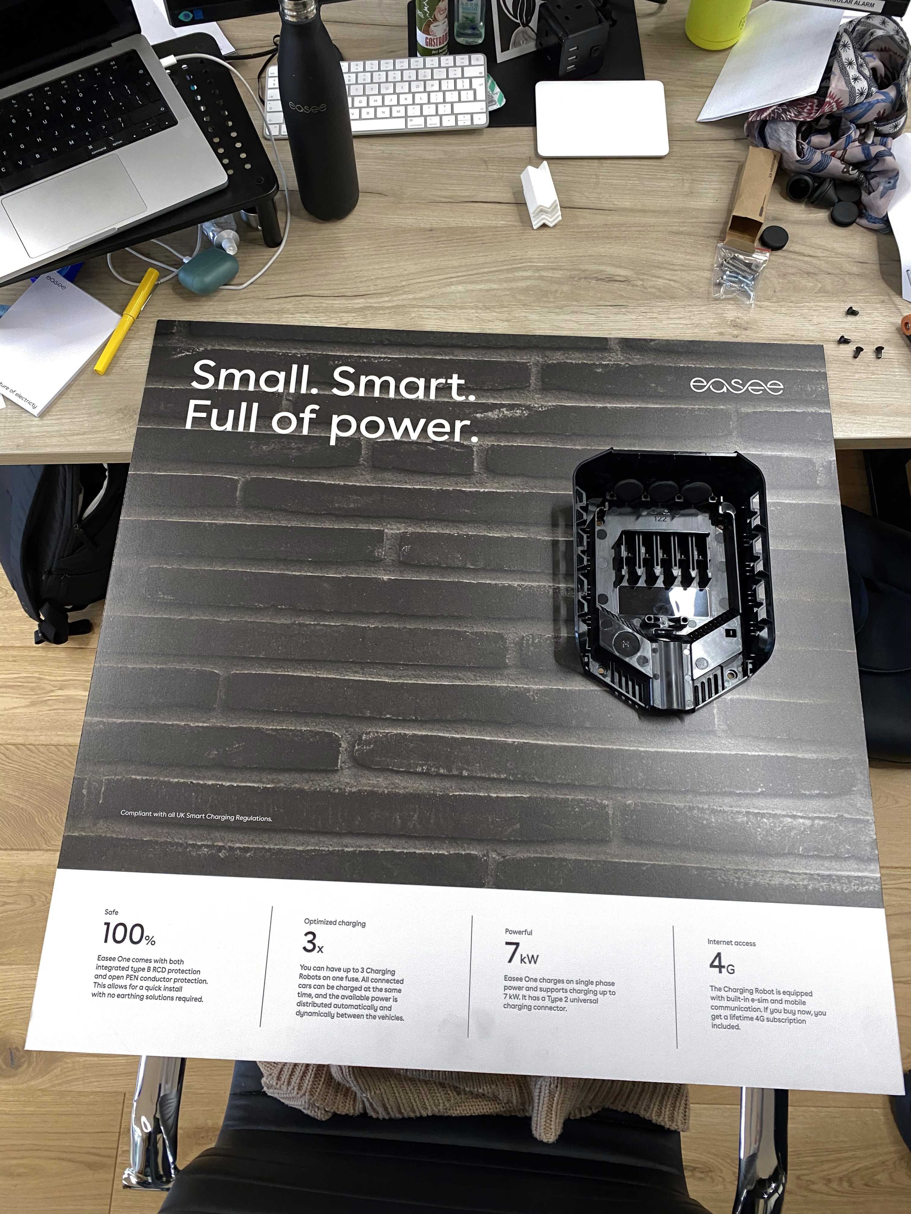 Modern home office setup with a monitor, ergonomic chair, keyboard, and indoor plants near a window with blinds.