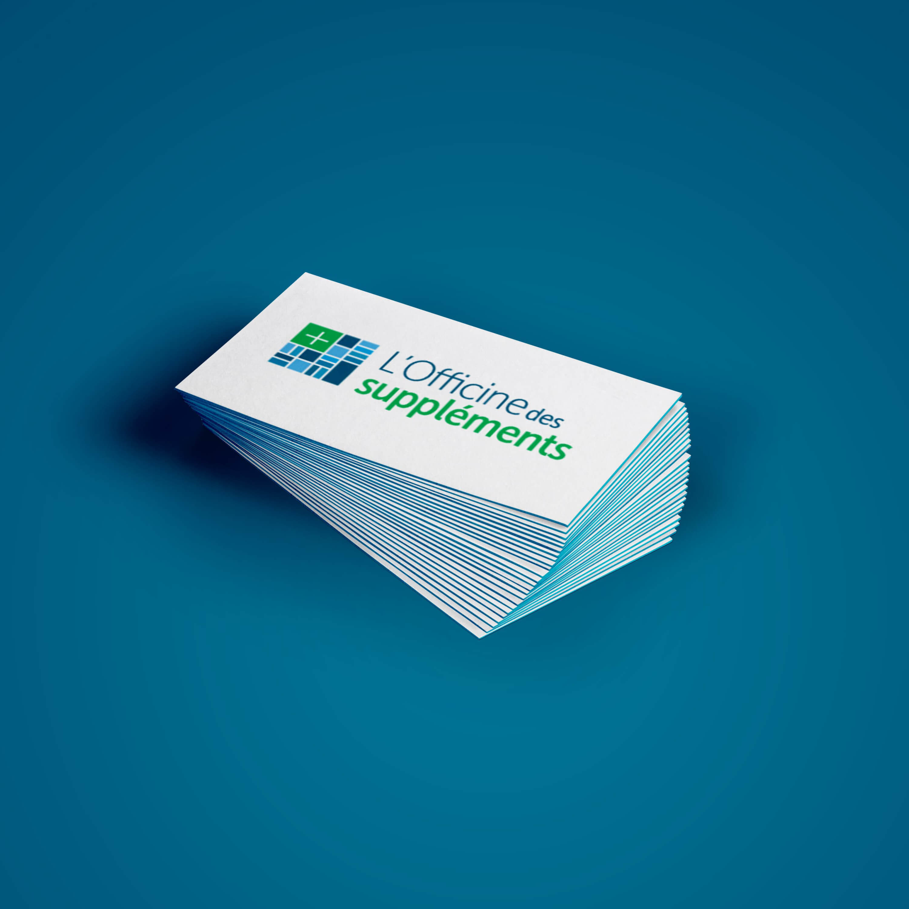 A stack of business cards for 'L’Officine des suppléments' displayed against a blue background. The card design features a modern logo composed of a green medical cross integrated into a blue grid icon, with the business name written beside it—'L’Officine des' in dark blue and 'suppléments' in green.