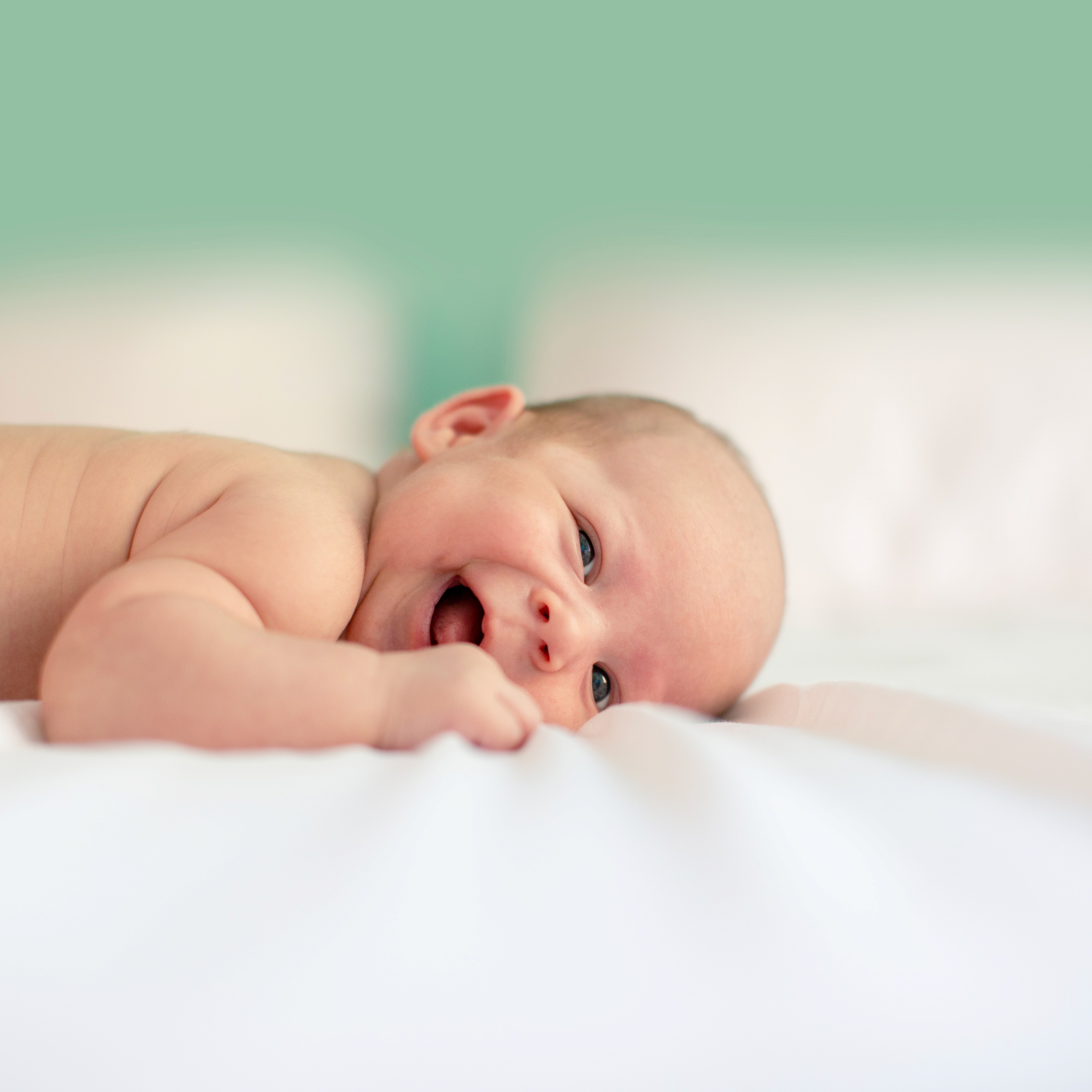 Baby lying on cloth. Look at that tiny spit up monster.