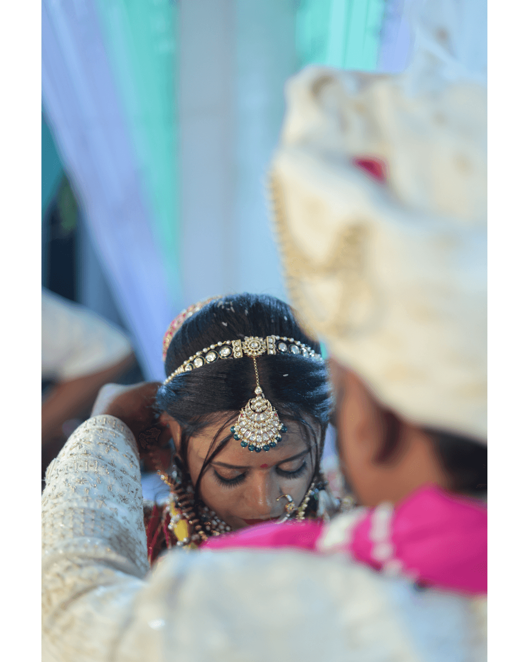 A bride in a white lace wedding dress holds a colorful bouquet of pink, yellow, and orange flowers.
