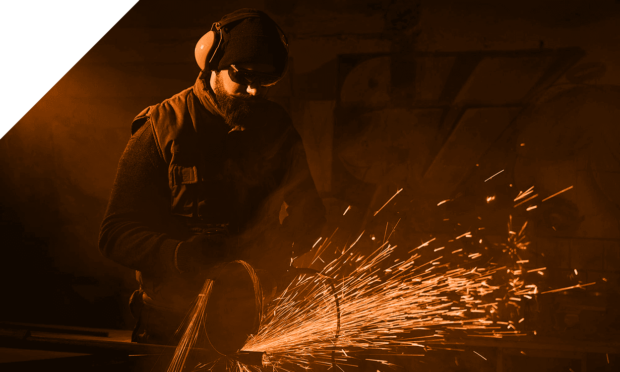 Guy welding with noise-canceling headphones on