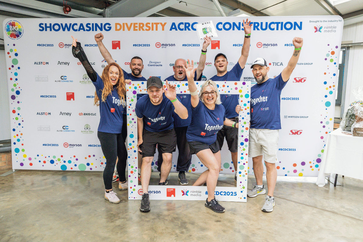 Outdoor team-building event with participants wearing matching blue shirts, taking part in inflatable obstacle courses and games, smiling and cheering, with the words 'ENTER A TEAM' in large bold white and green text across the image.