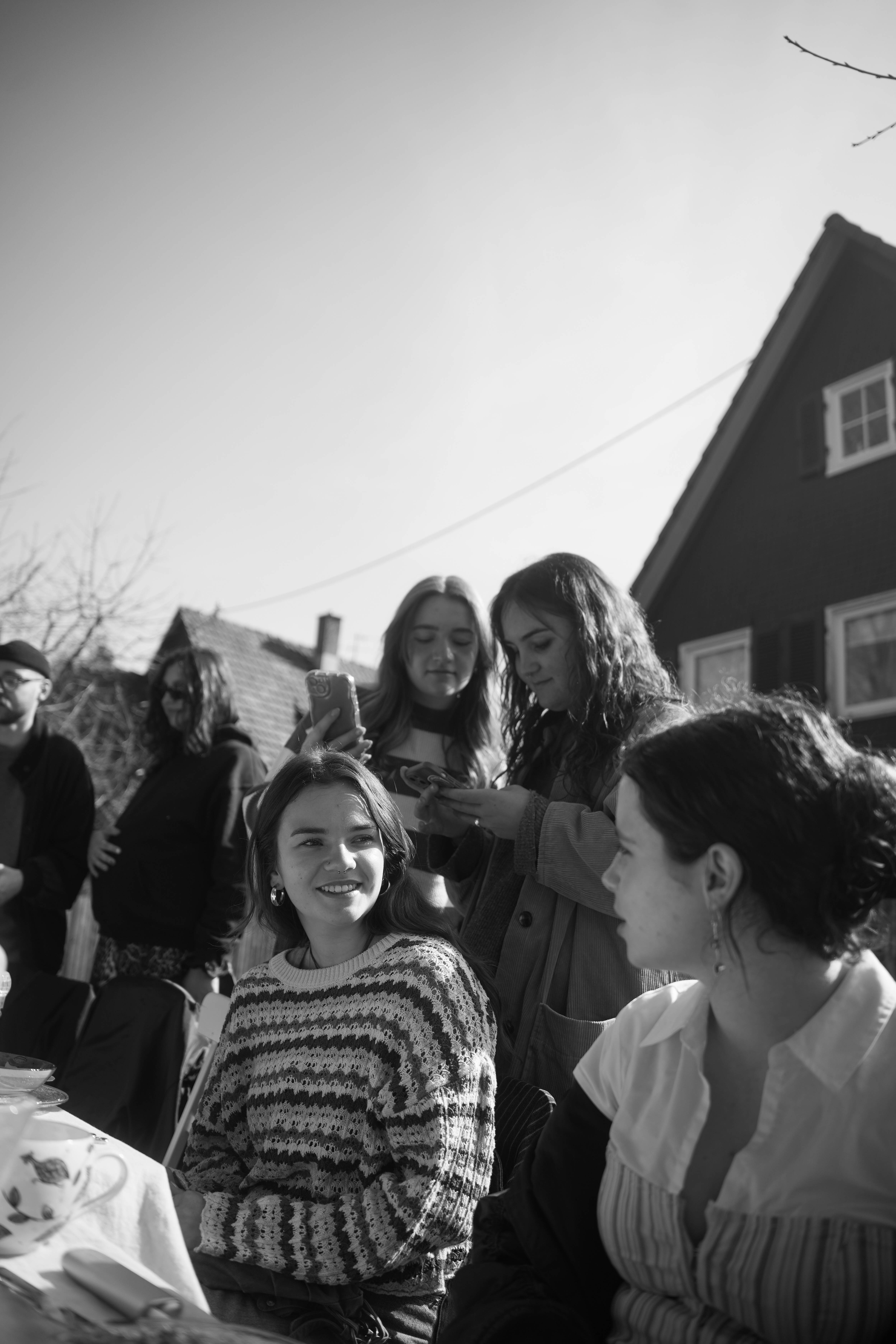 Black and white portrait of a smiling person with curly hair