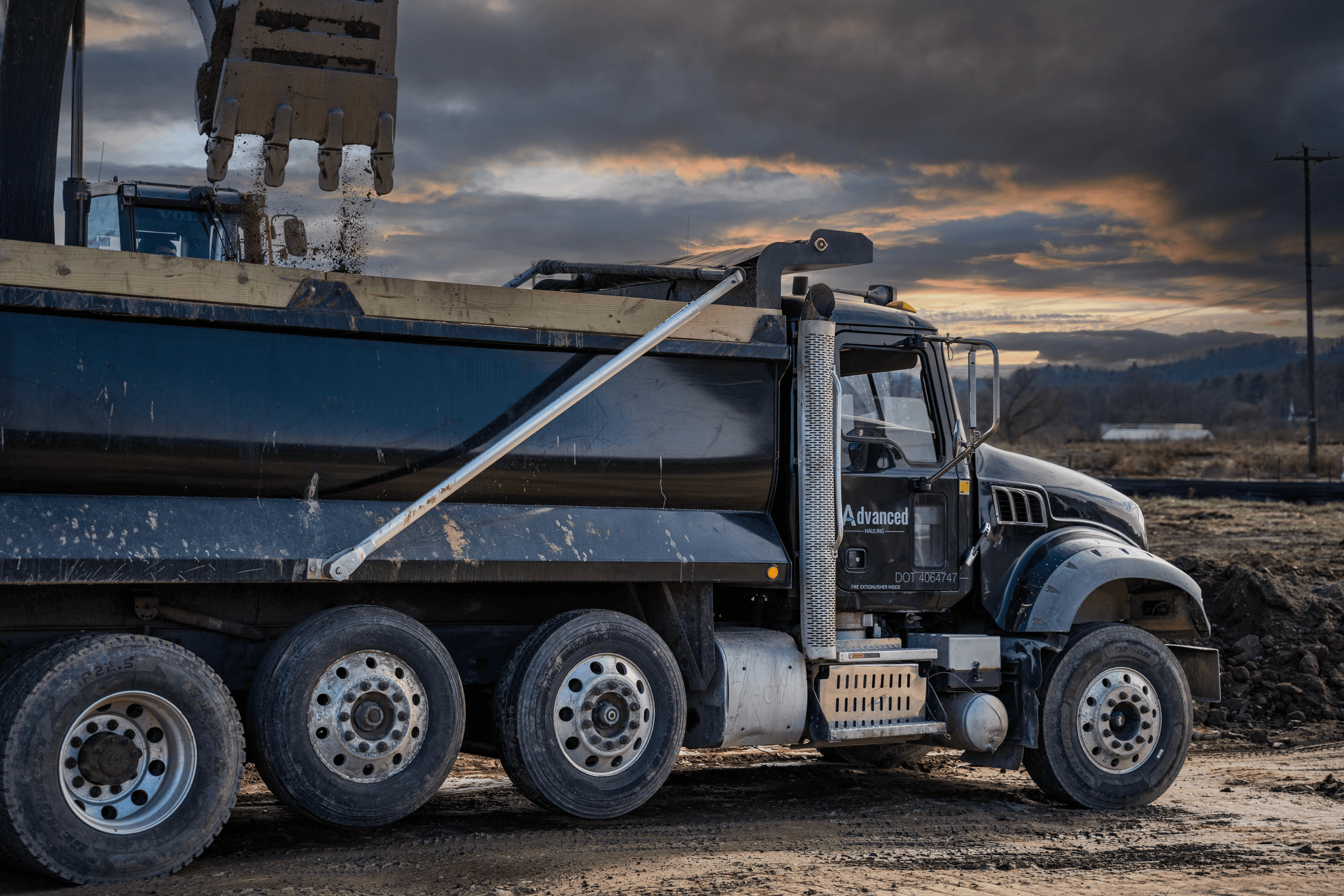 EXCAVATOR LOADING DUMP TRUCK WITH DIRT