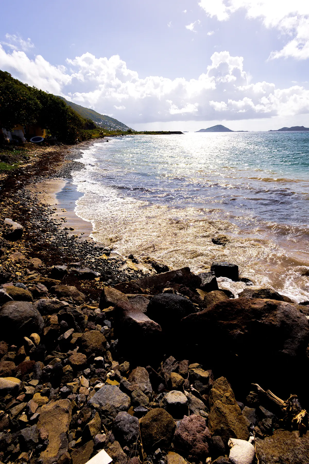 Silhouette of a woman stretching with arms raised at sunset by the water, golden light reflecting on the surface