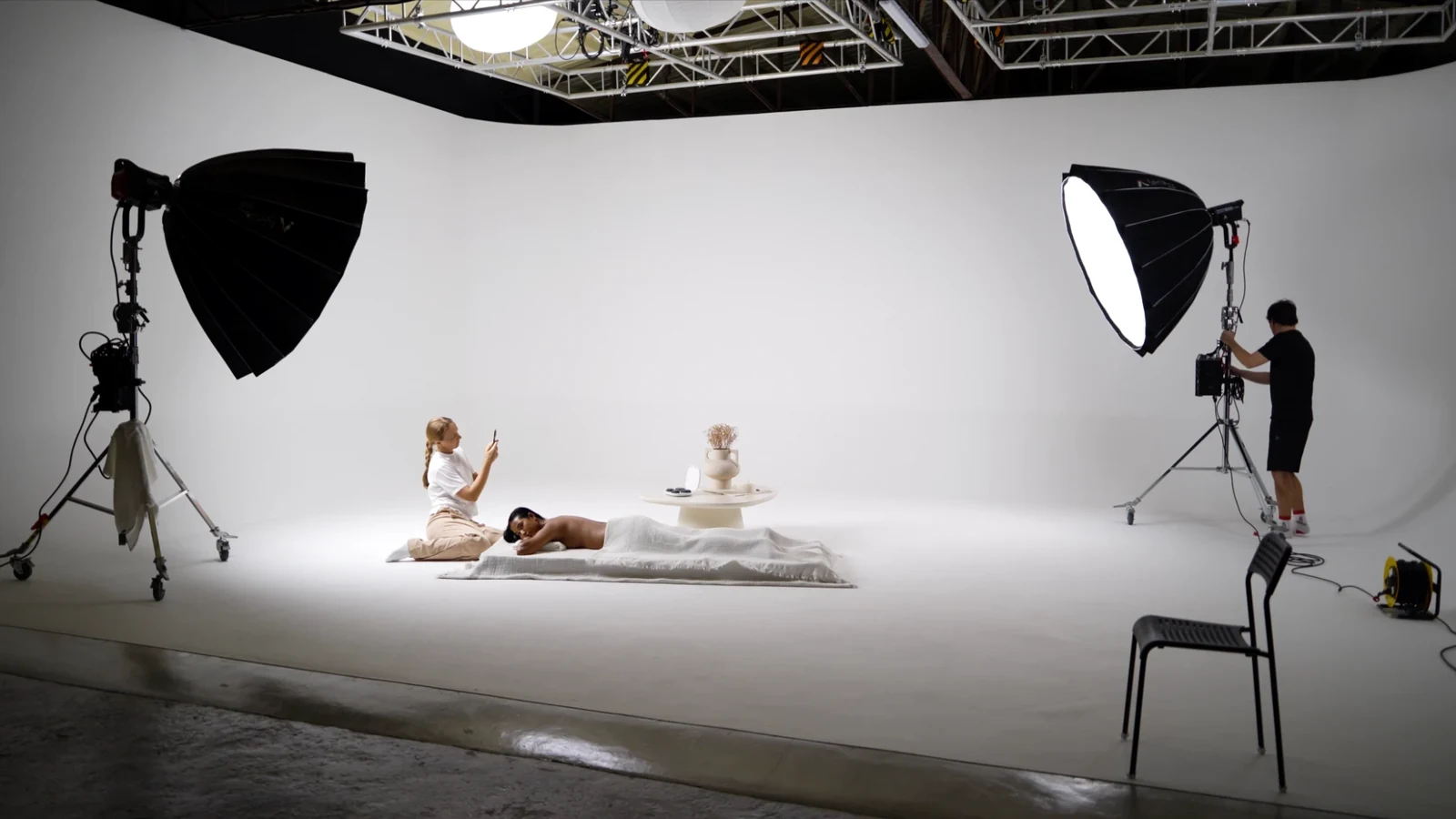 Wide view of the hot stone massage scene on the white cyclorama with two large softboxes