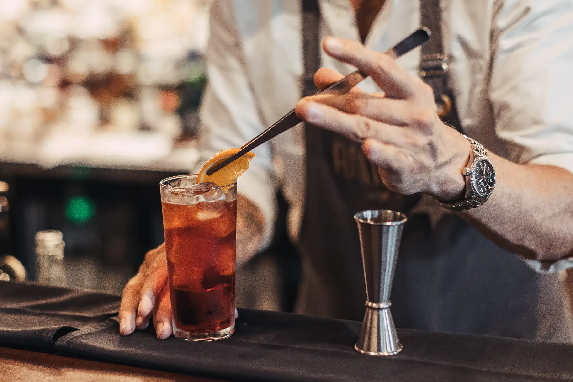 Bartender garnishing a Negroni with orange peel at the ANNATA bar