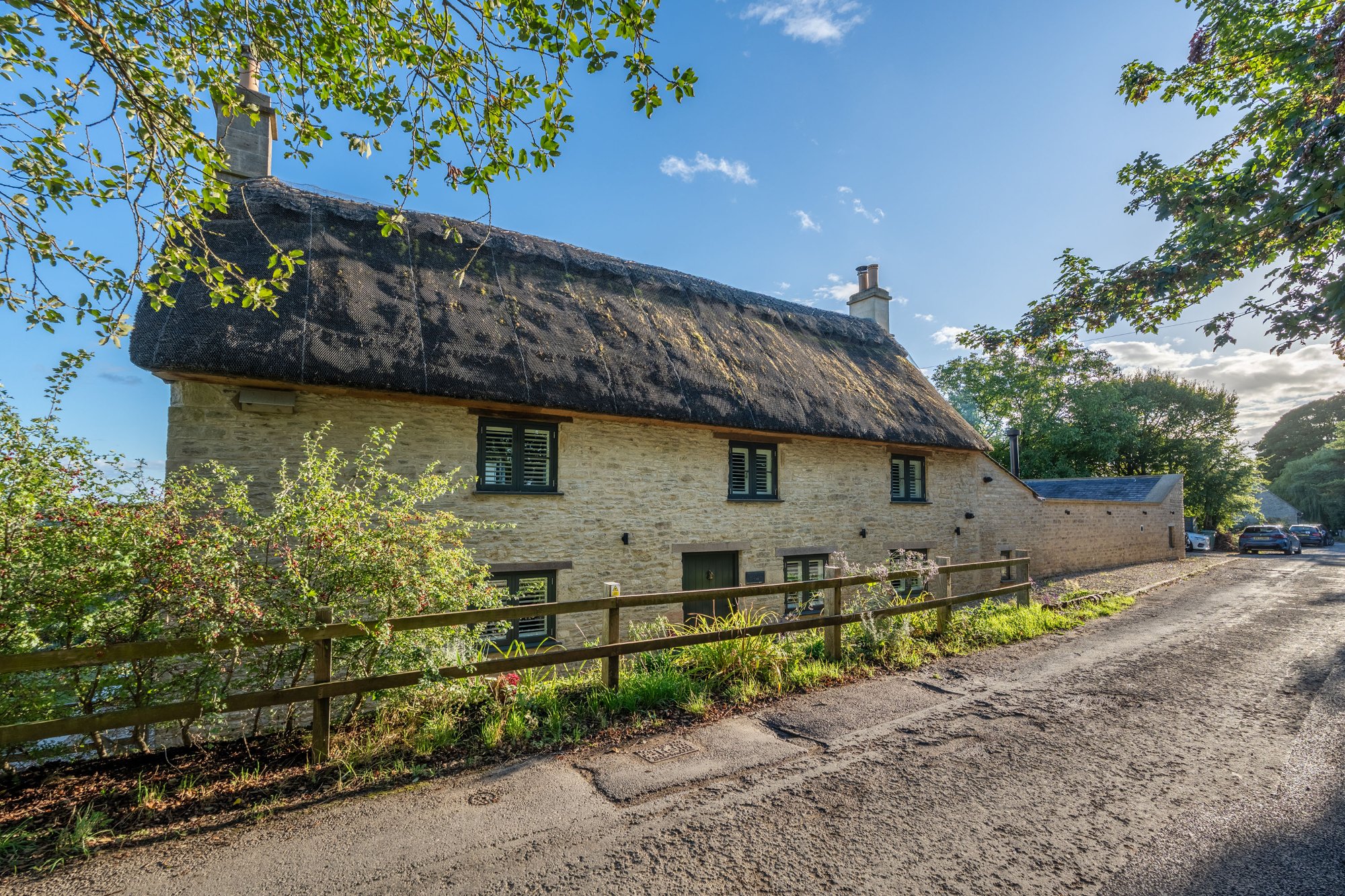 Thatched stone cottage seen from the village lane in Cold Ashton, South Gloucestershire — property photography by Captura Media