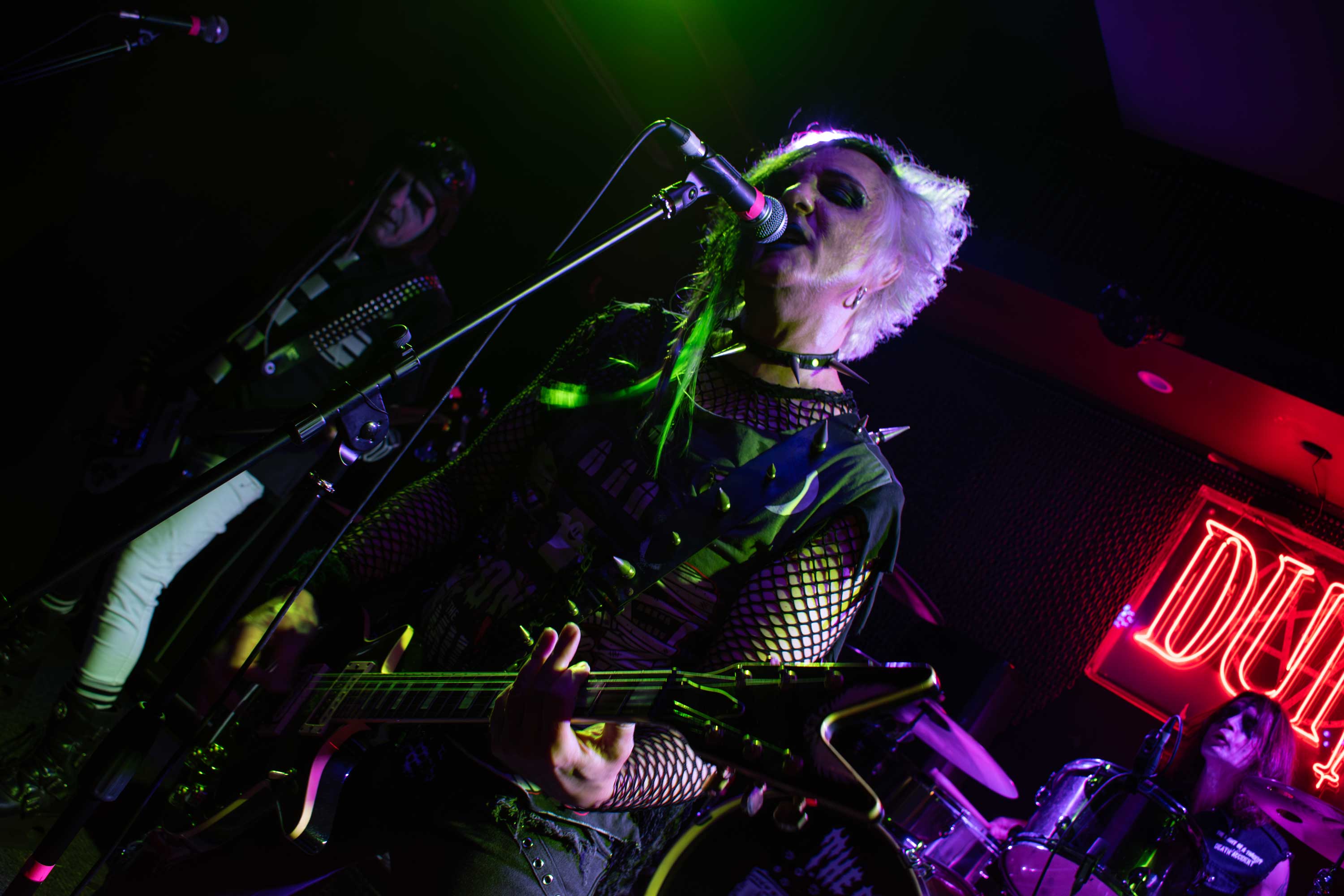 Guitar teacher on stage playing guitar and singing in a band