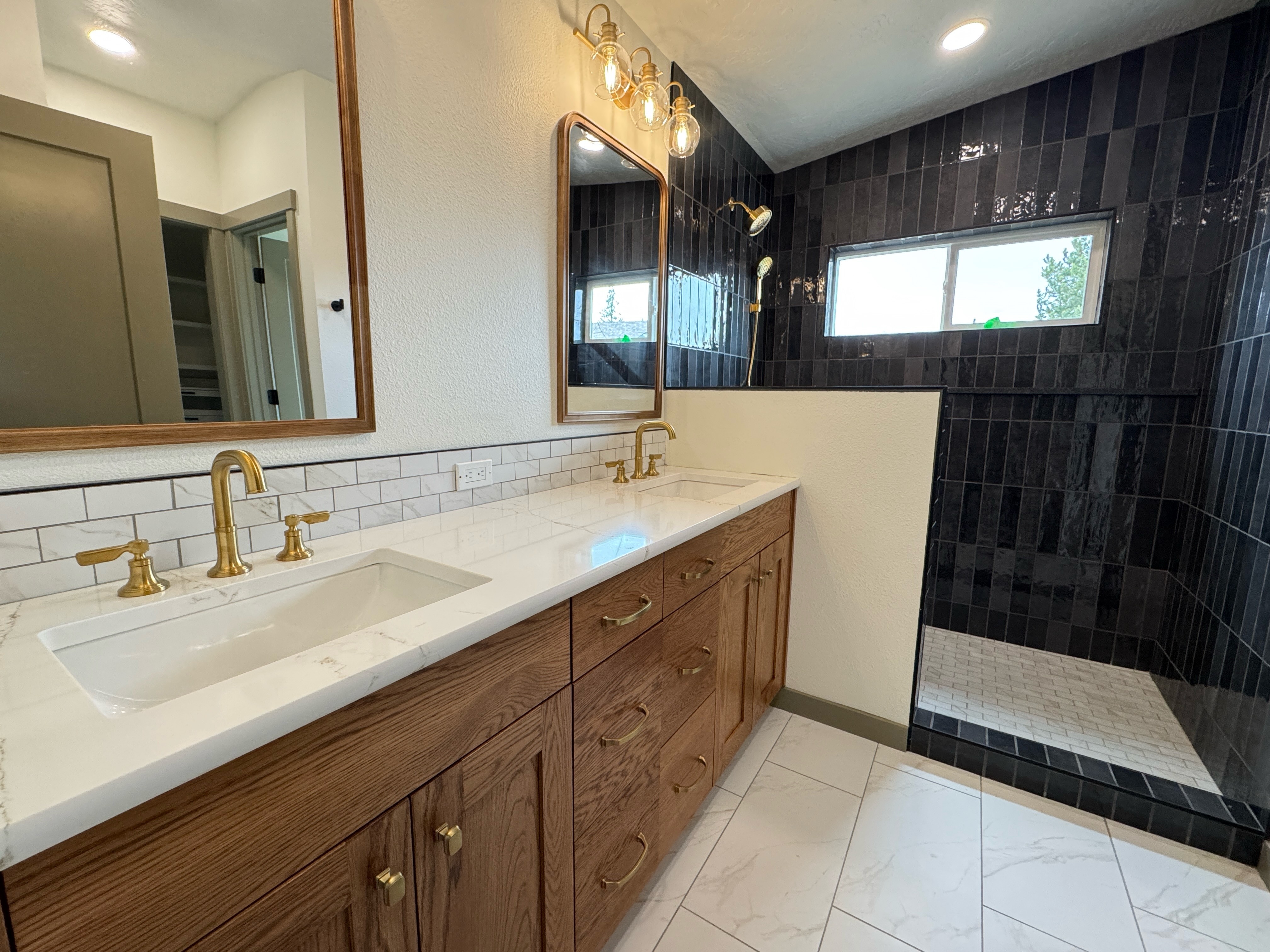 A winding road cuts through rocky terrain, surrounded by patches of green grass and illuminated by sunlight.