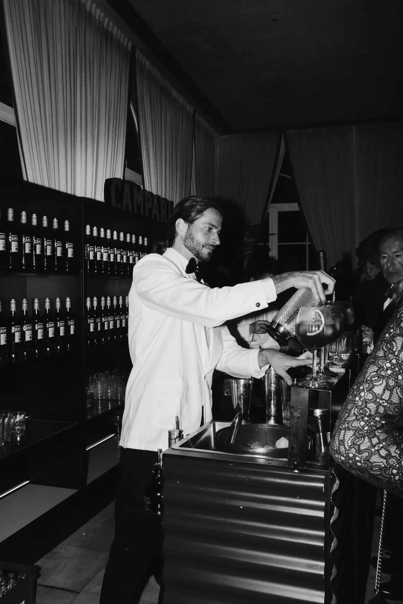 Barman detrás de la barra preparando un coctel