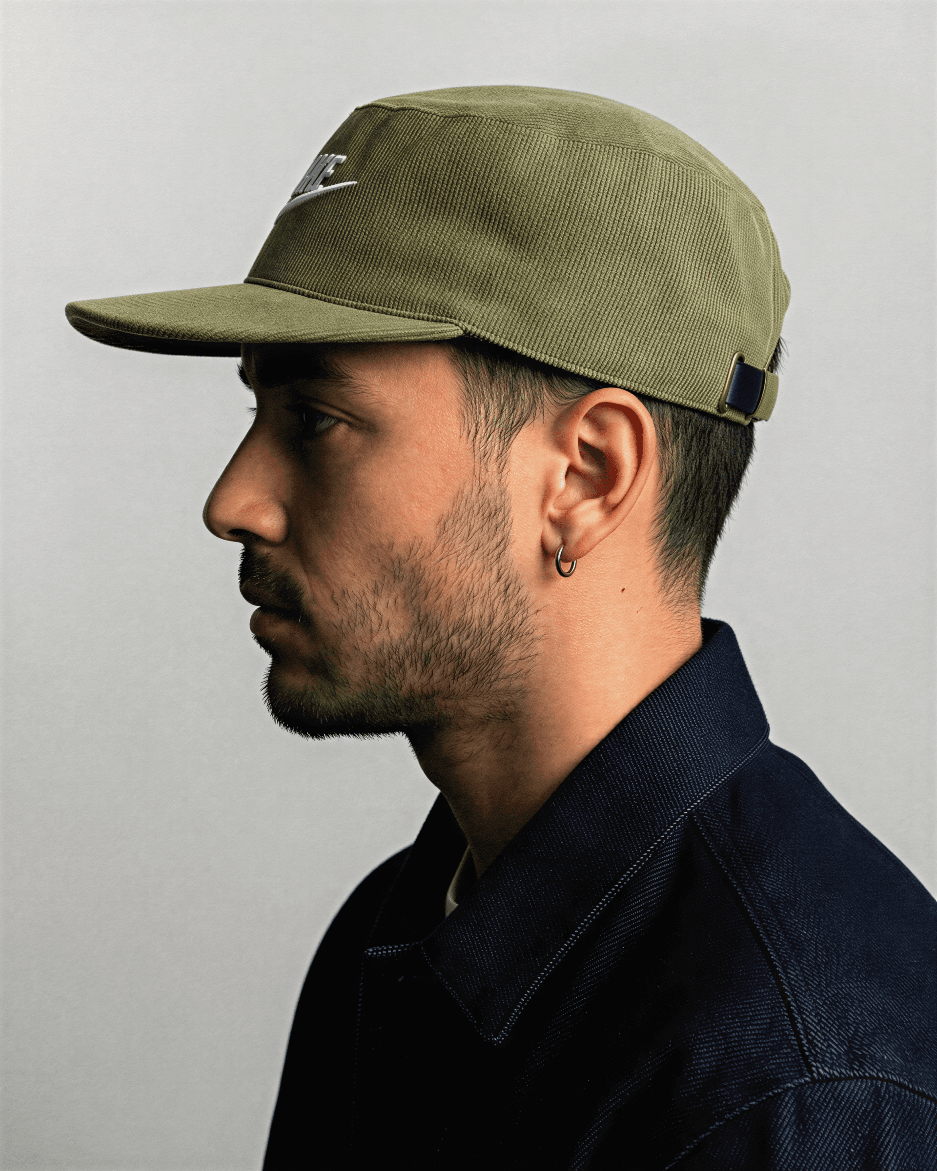 Man wearing a green cap against a plain background
