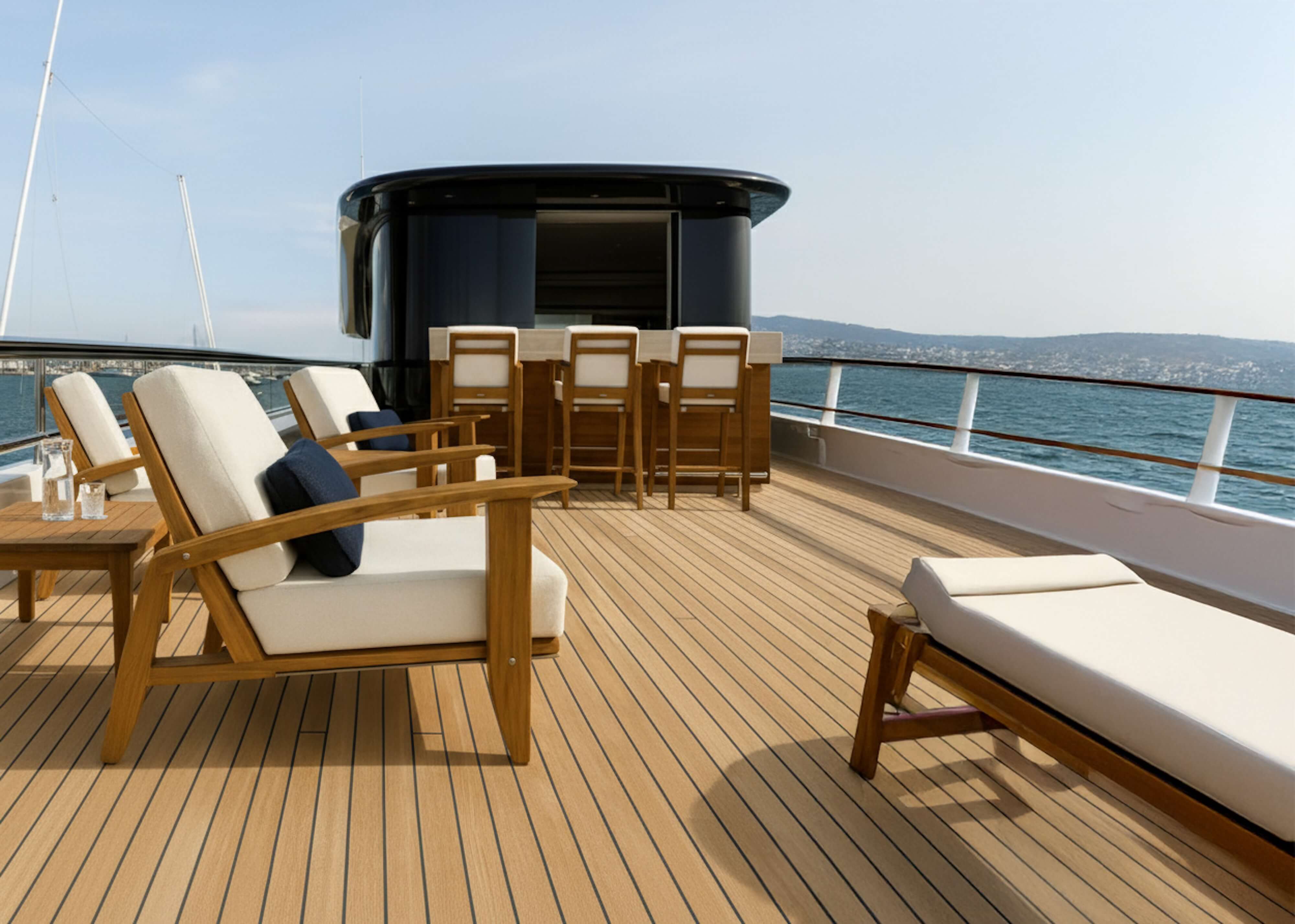 Elegant teak yacht deck with sculptural lounge seating, bar stools, and ocean horizon — a refined outdoor setting for elevated onboard living.