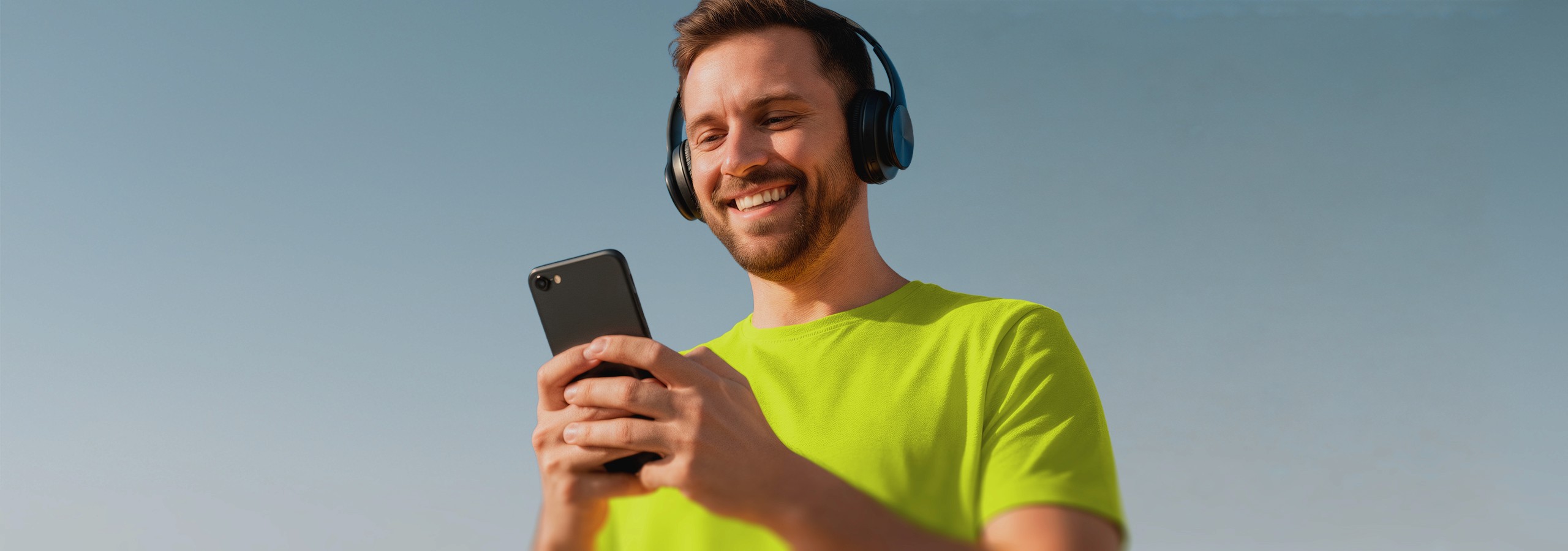 Homem sorridente usando um iphone e headphone