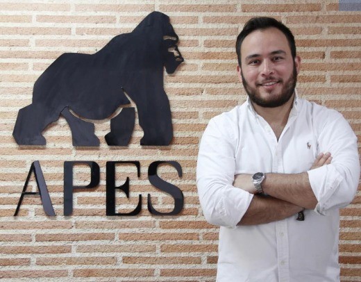Aerial view of a winding road cutting through rocky terrain and sandy landscape.