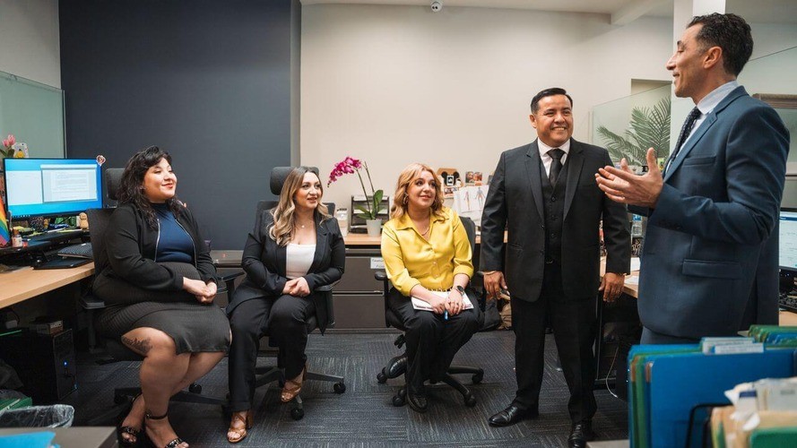 Three professionals posing together in an office.