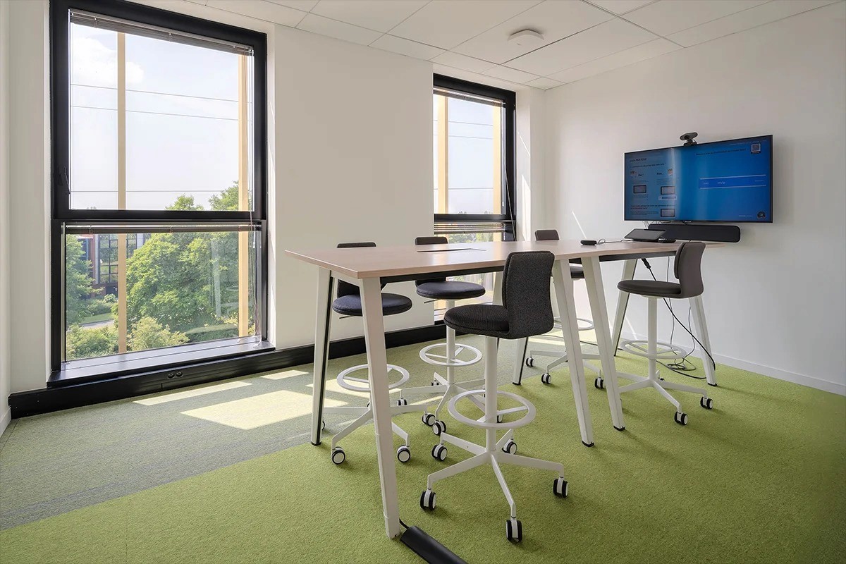 Espace de travail lumineux au sol vert et grandes fenêtres — photographie bureaux contemporains Lille Nord | Anteale Yann Manac’h