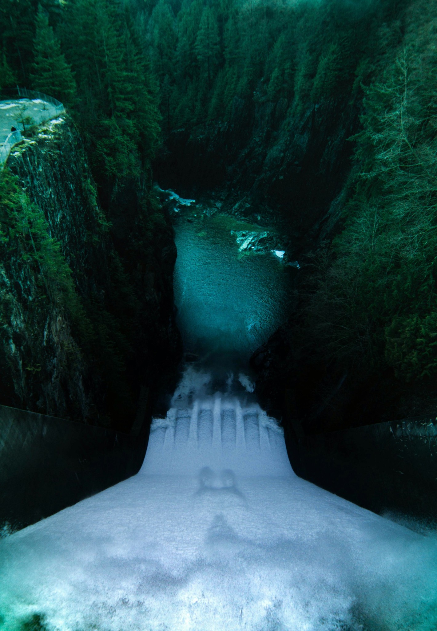 Ein leistungsstarker Damm, der Wasser in eine tiefe Schlucht abgibt und eine wichtige hydroelektrische Struktur für erneuerbare Energie und Wassermanagement zeigt.