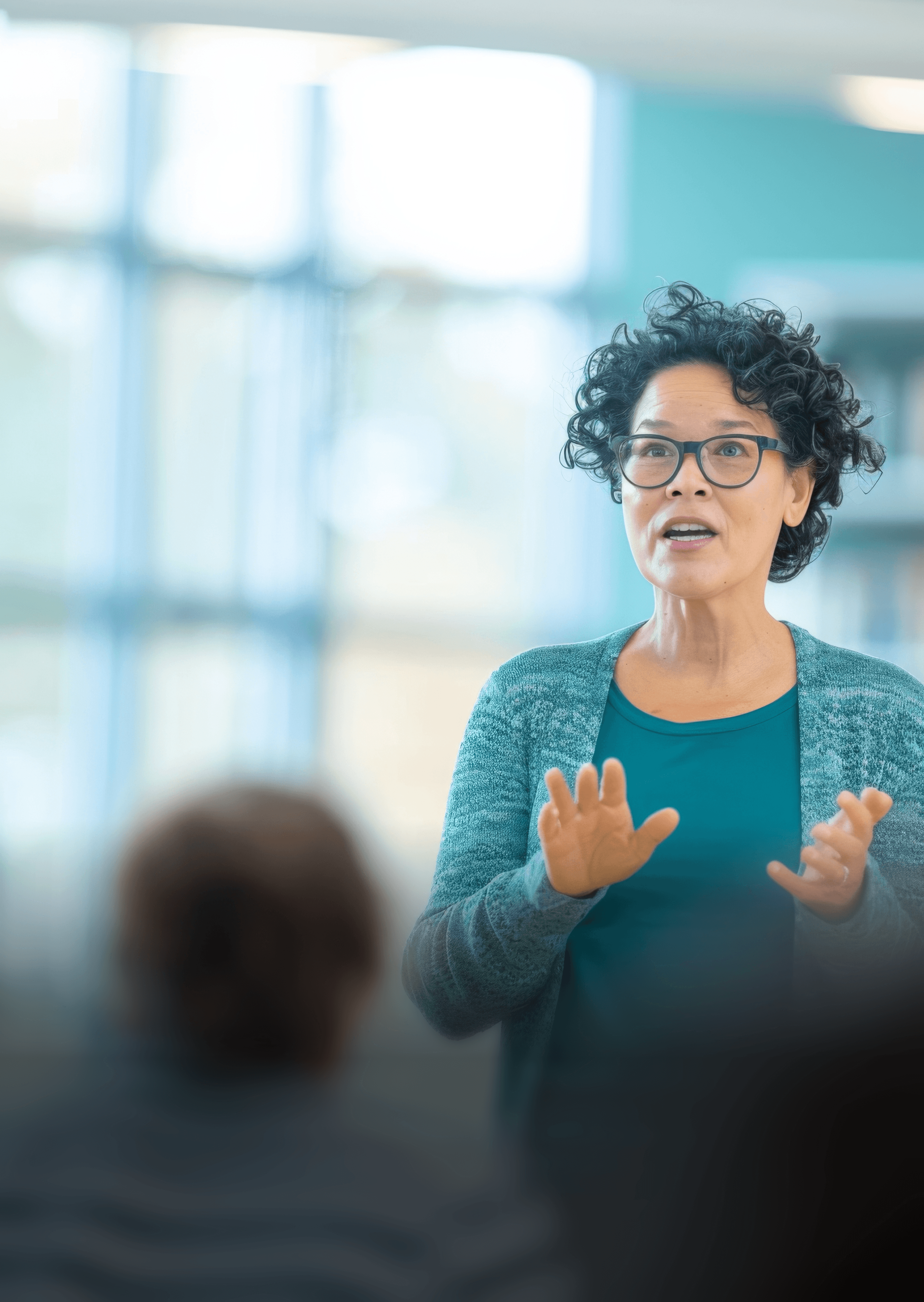 photo of a woman talking or presenting to some people