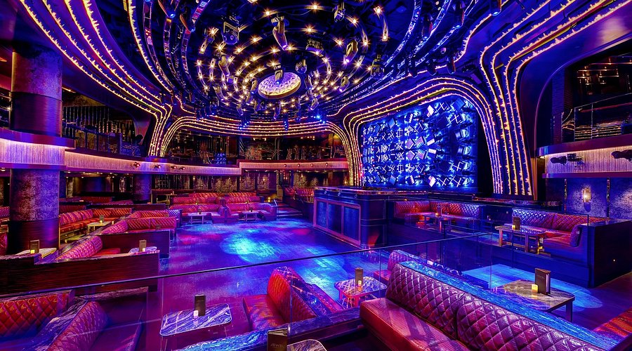 Nightclub with plush seating and colorful lighting.
