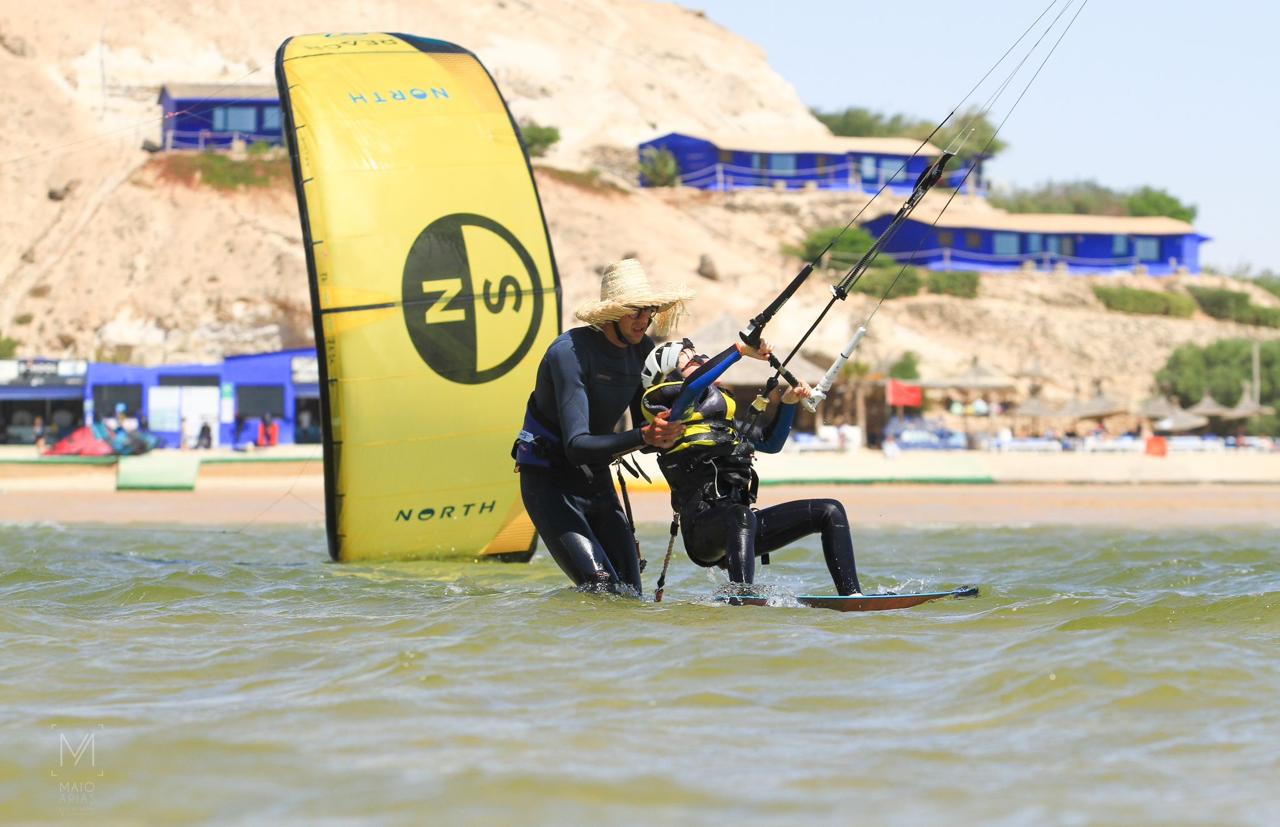 A man stading with Surfboard