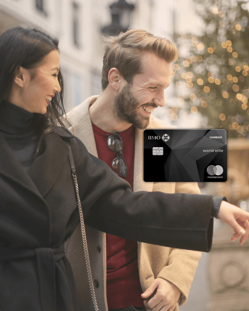 A smiling, established couple walking outdoors in a city, with a black BMO CashBack World Elite Mastercard graphic overlaid, representing the premium 5% grocery cash-back card for families and established newcomers in Canada.