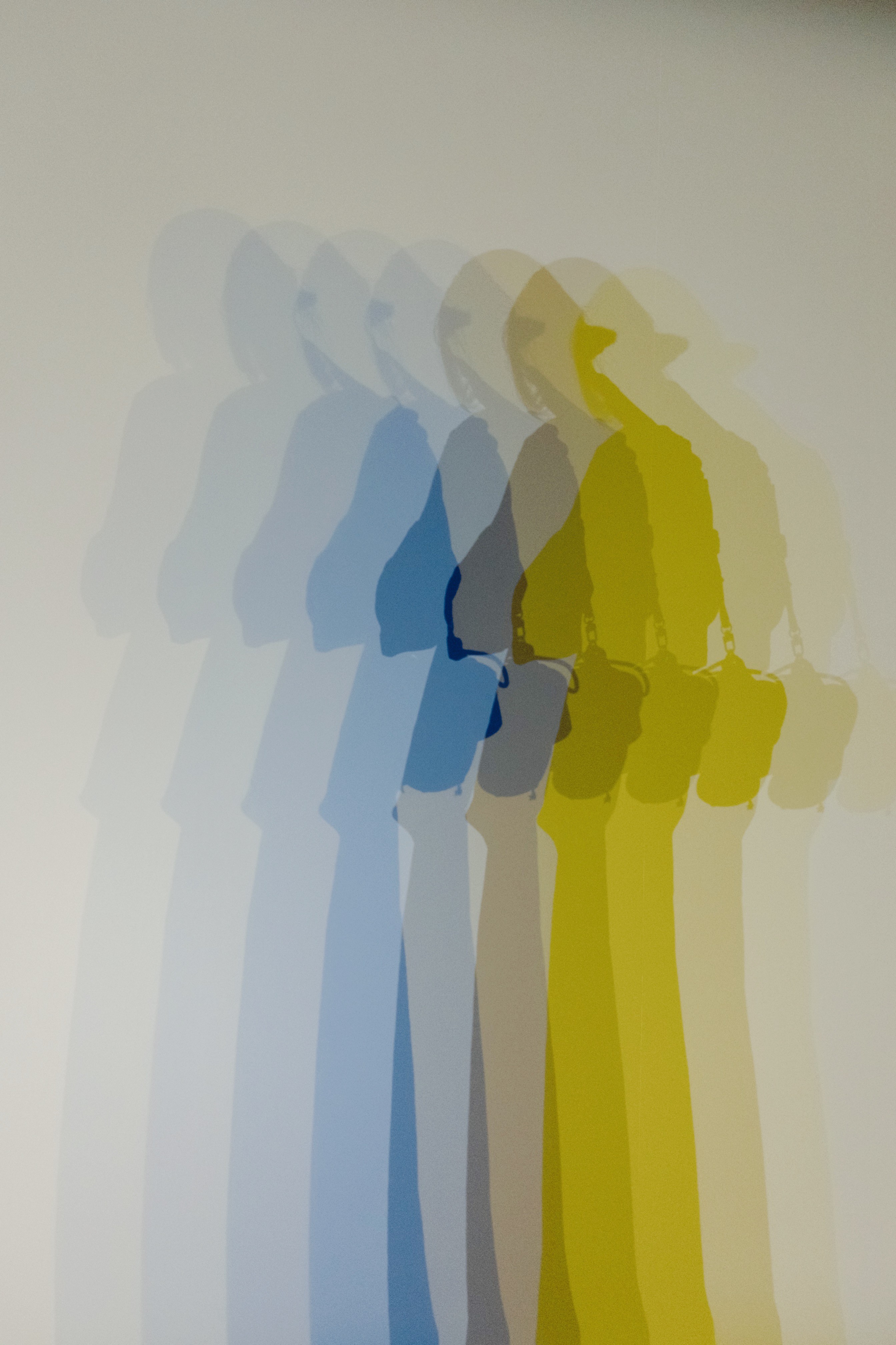 A close-up of a person wearing green-tinted glasses, with a serious expression and smooth skin.