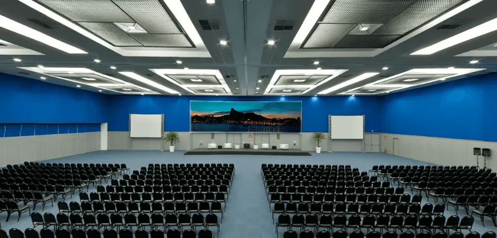A large auditorium with rows of chairs and a stage
