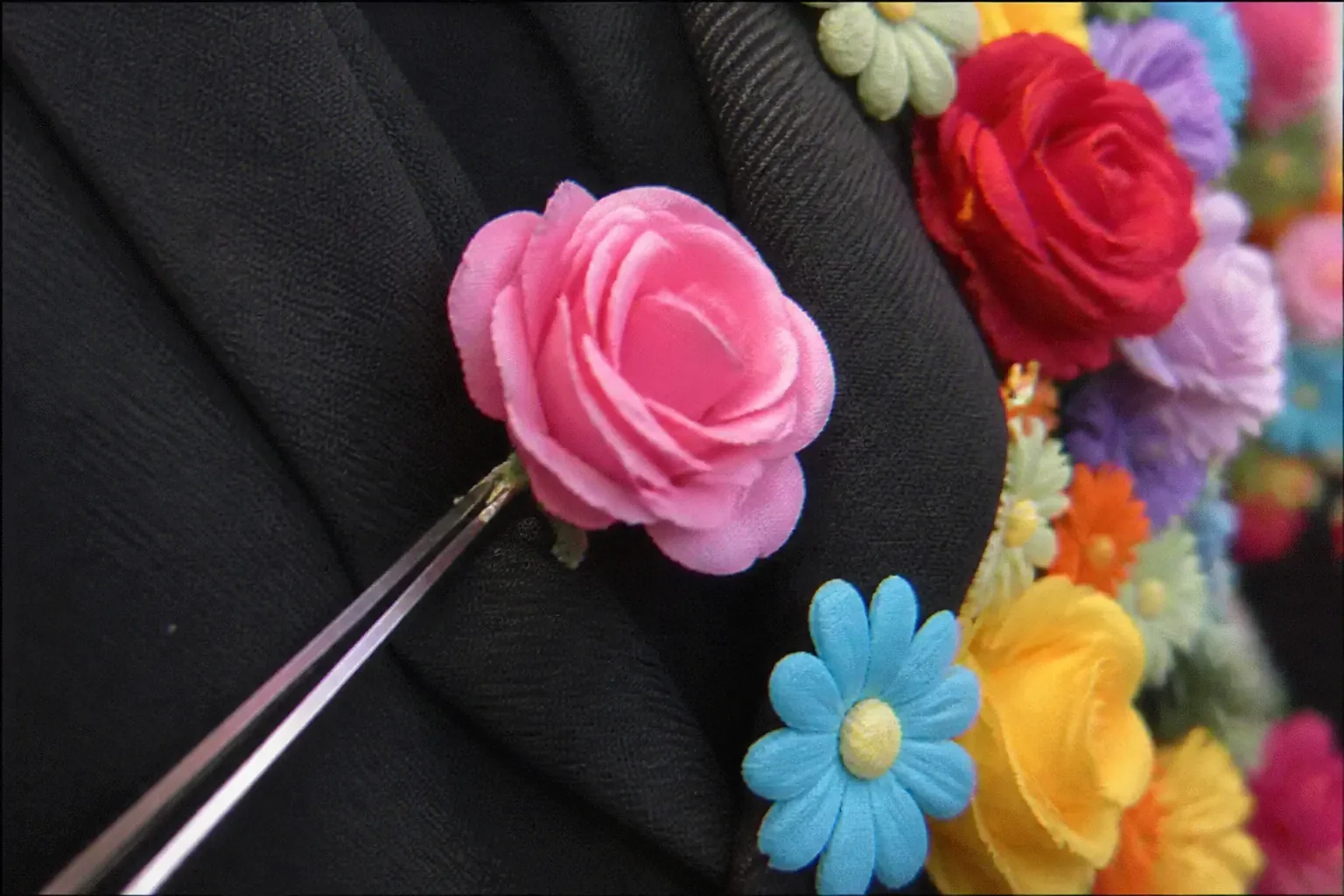 Le Fleuravelle, a black formal suit covered with dense artificial flowers.