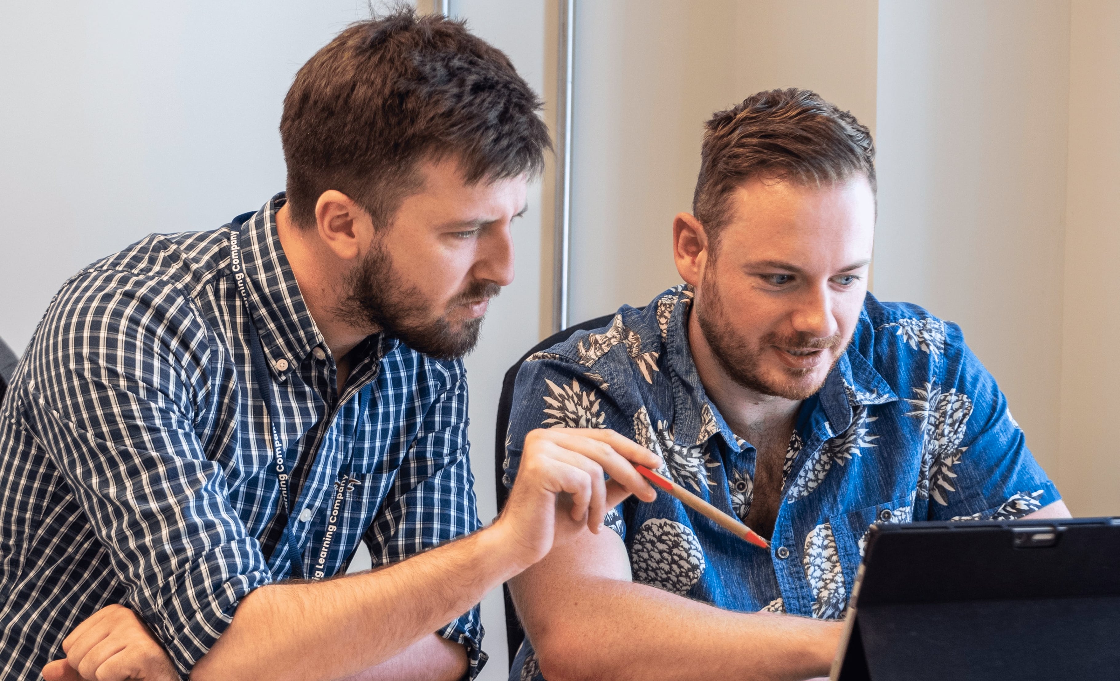Two people working with a laptop computer.