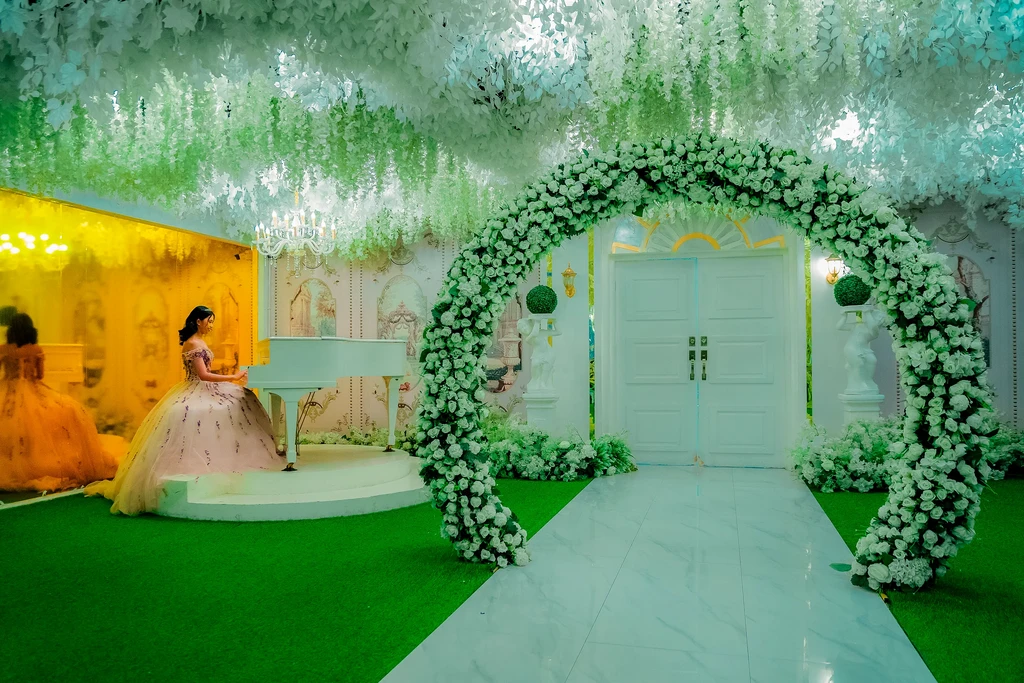 Debutante in a champagne gown by the garden arch at Celestia Hall