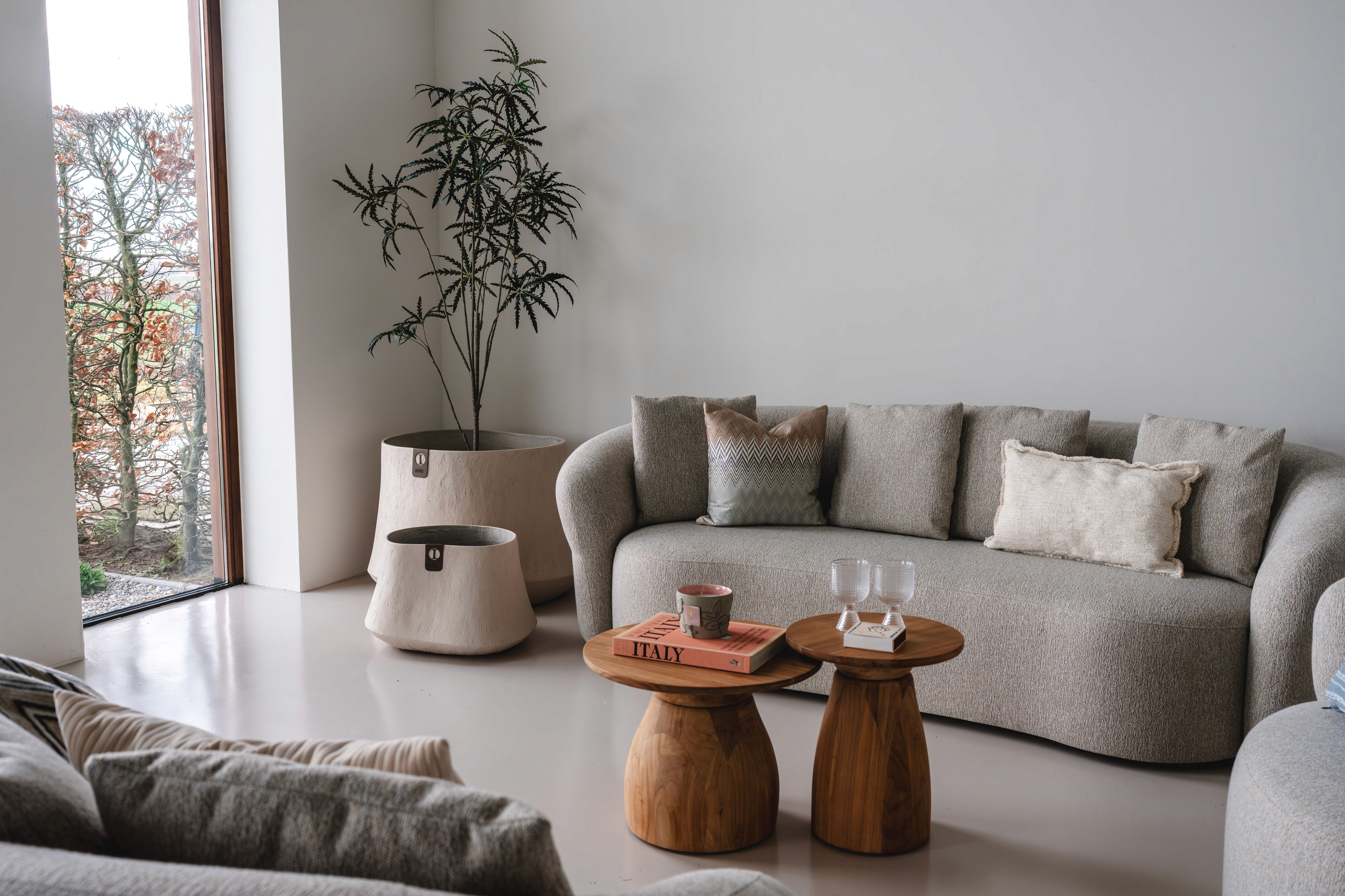 Luca Lifestyle Lichte zithoek met fauteuil, plaid en kamerplant in een gestileerd interieur.