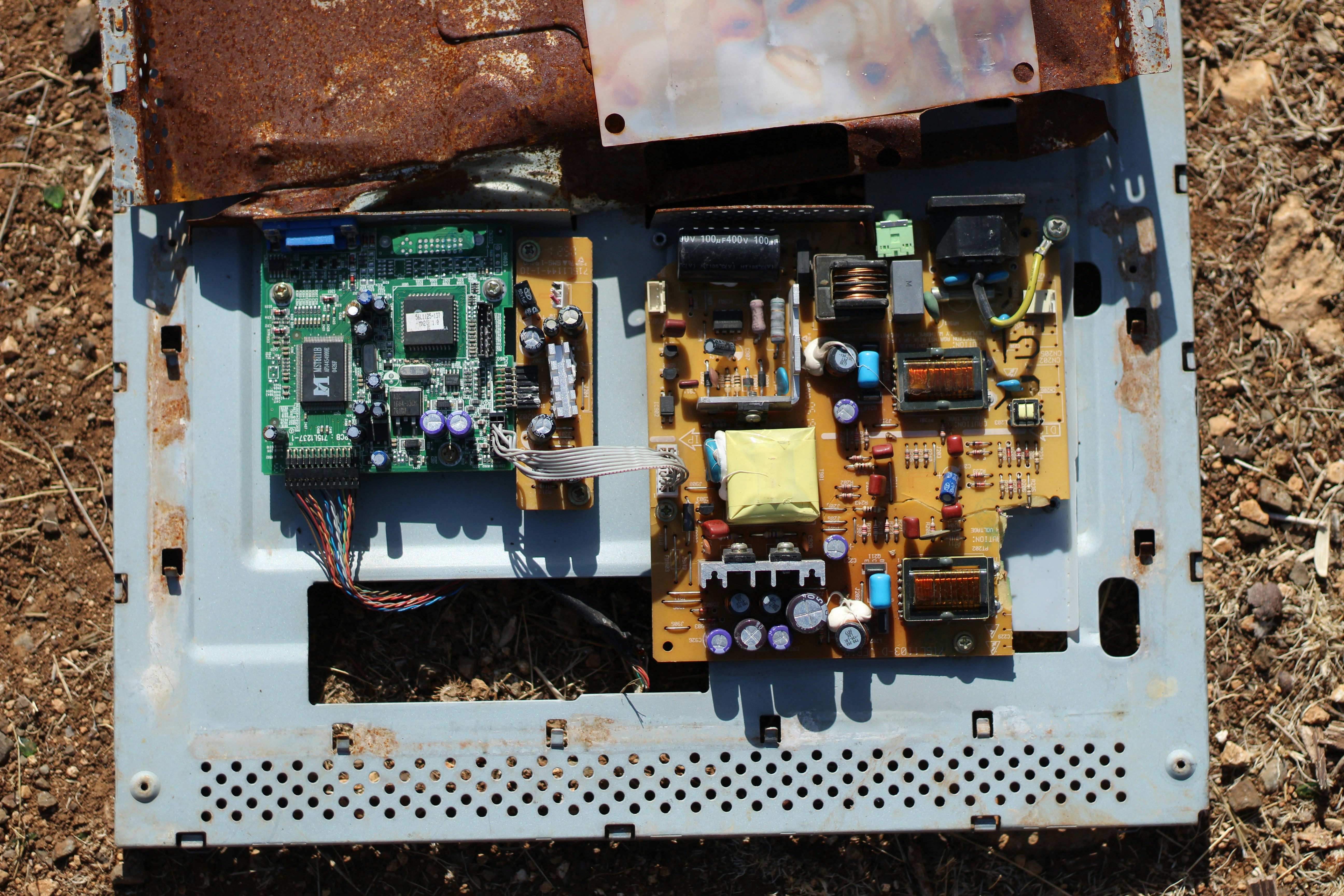 Discarded electronic circuit boards on the ground.